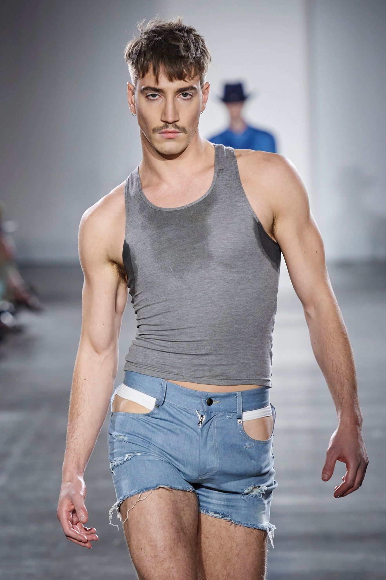 Model walking for London College of Fashion MA student Zhongzhi Ding's graduate collection 2023 with a dildo in his shorts.