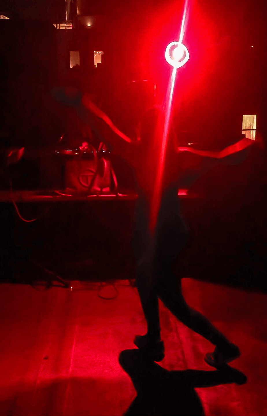 a dancer lit by red light at a rave