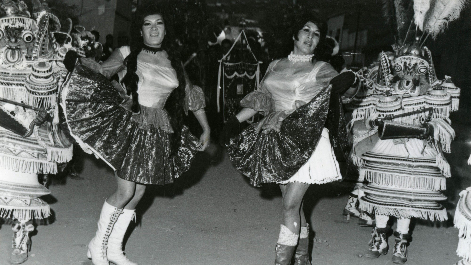 Two travesti performers dressed as La China Morena dancing in the streets of Huanuni, Bolivia