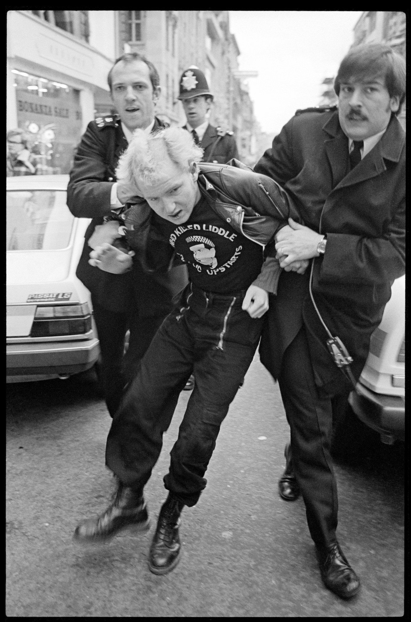 police holding a punk back at the sid vicious march 1980