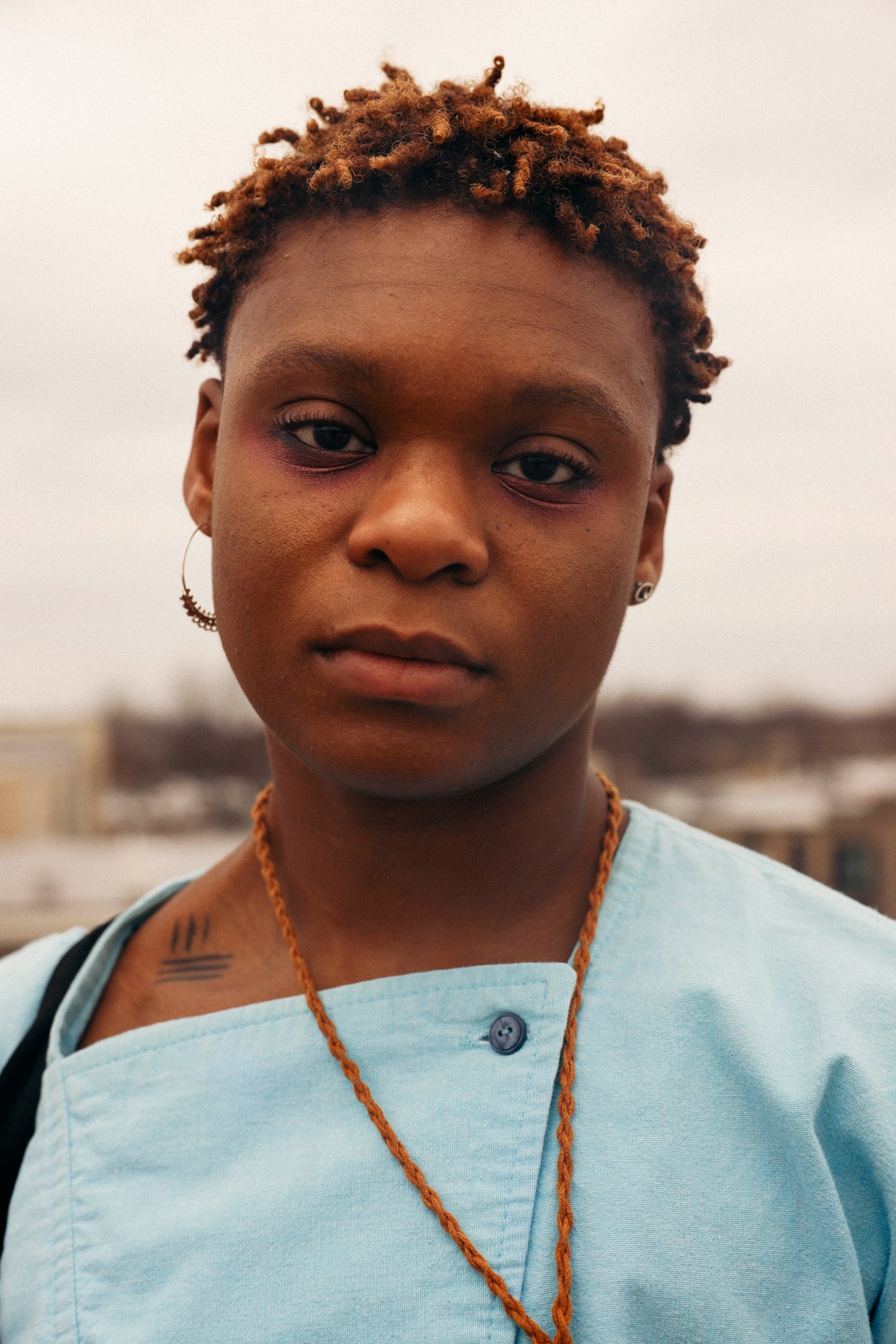 close up portrait of dreamer isioma in a blue shirt and earrings