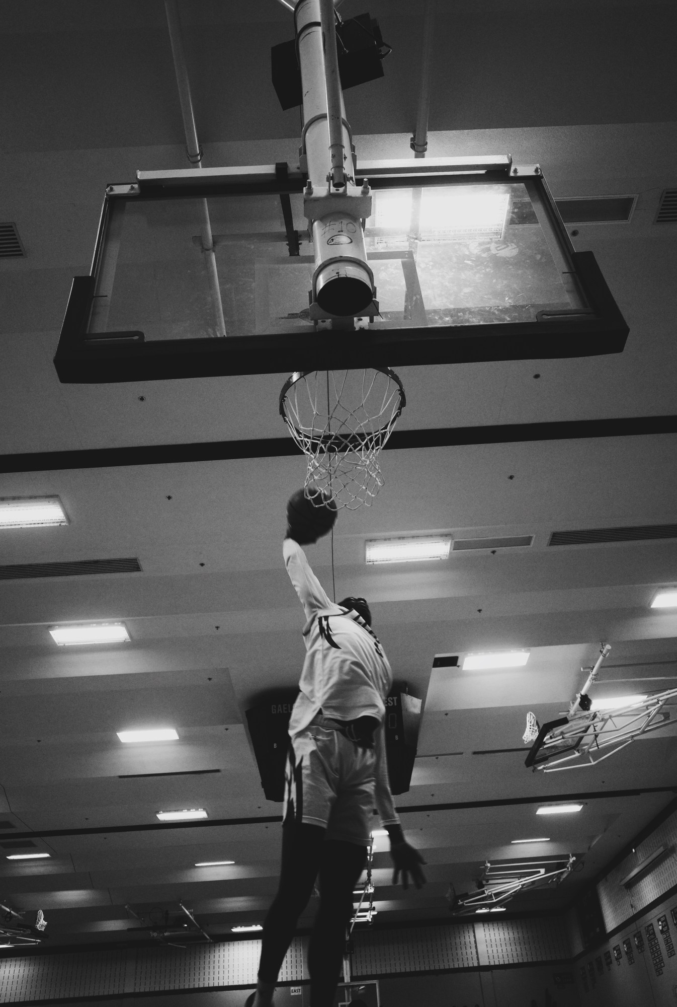 a young man in a white uniform dunking a basketball