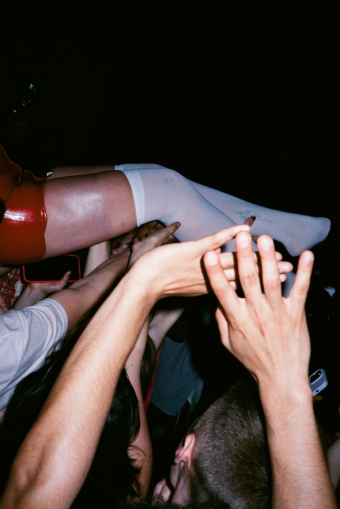 a crowd of fans lifting up eartheater as she crowsurfs