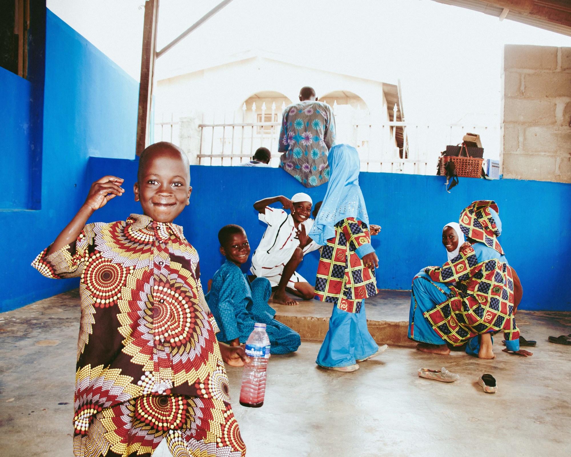 kids dressed in colorful tunics in a mosque in nigeria