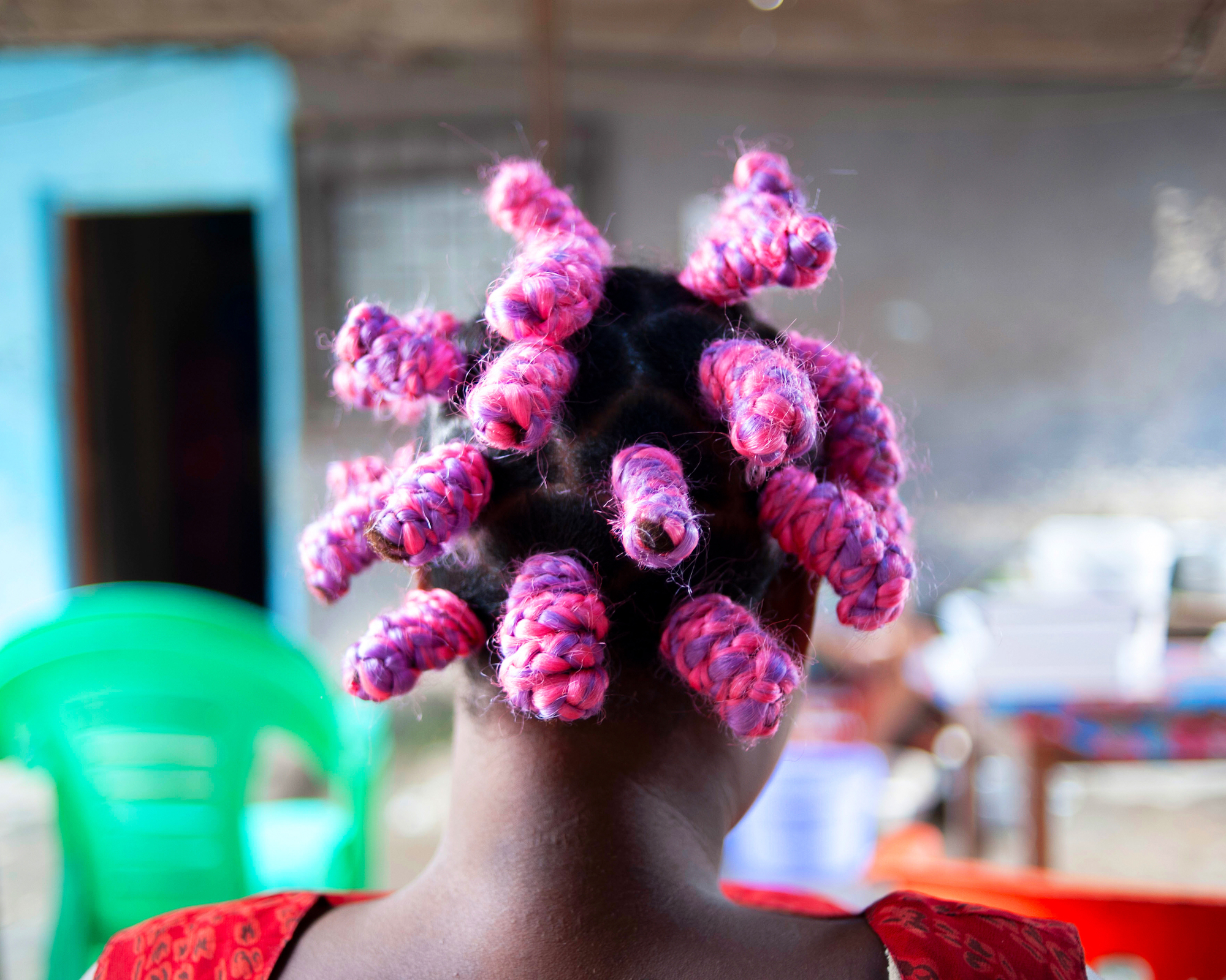 a woman with pink bantu knots