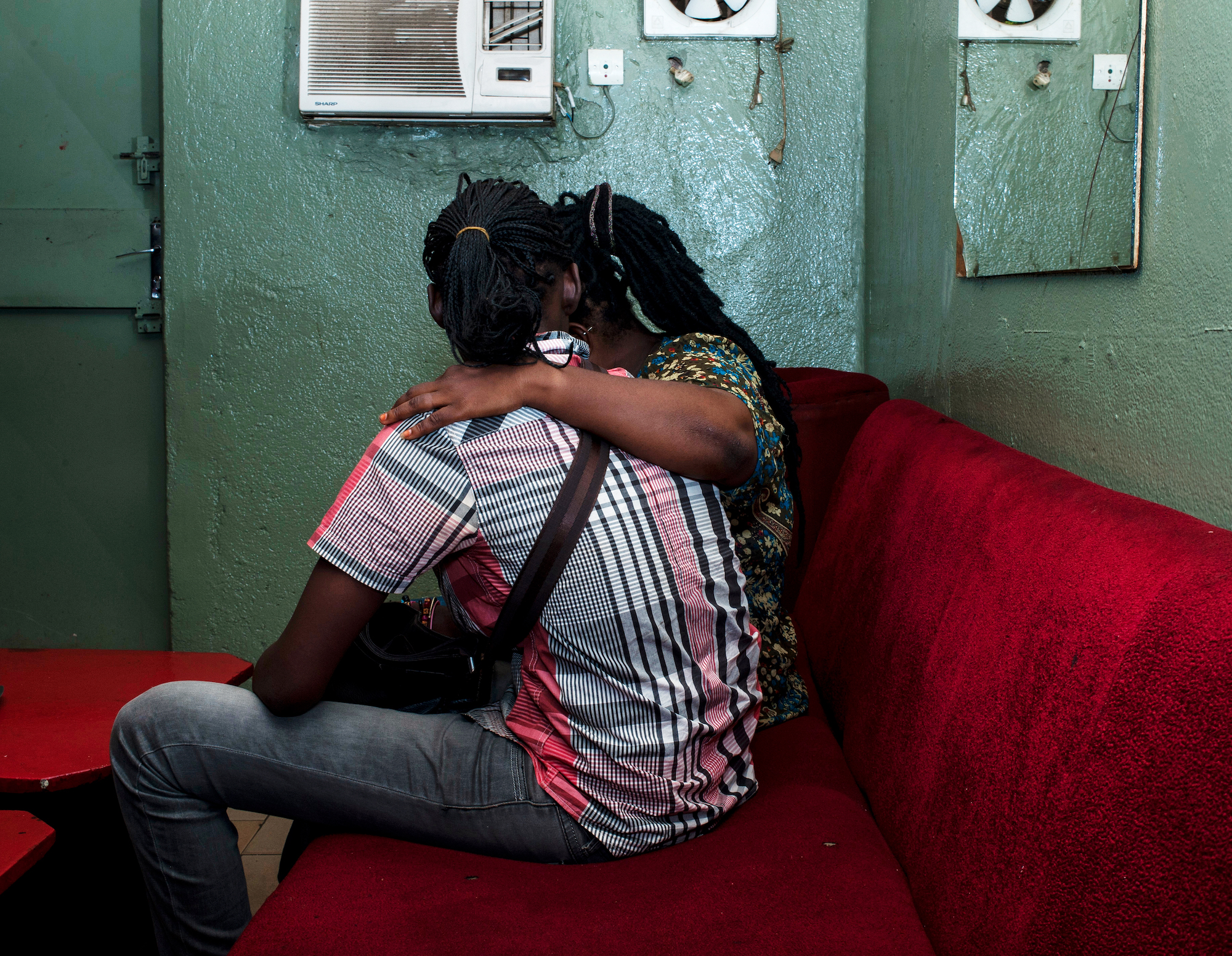 two lovers embracing on a red couch