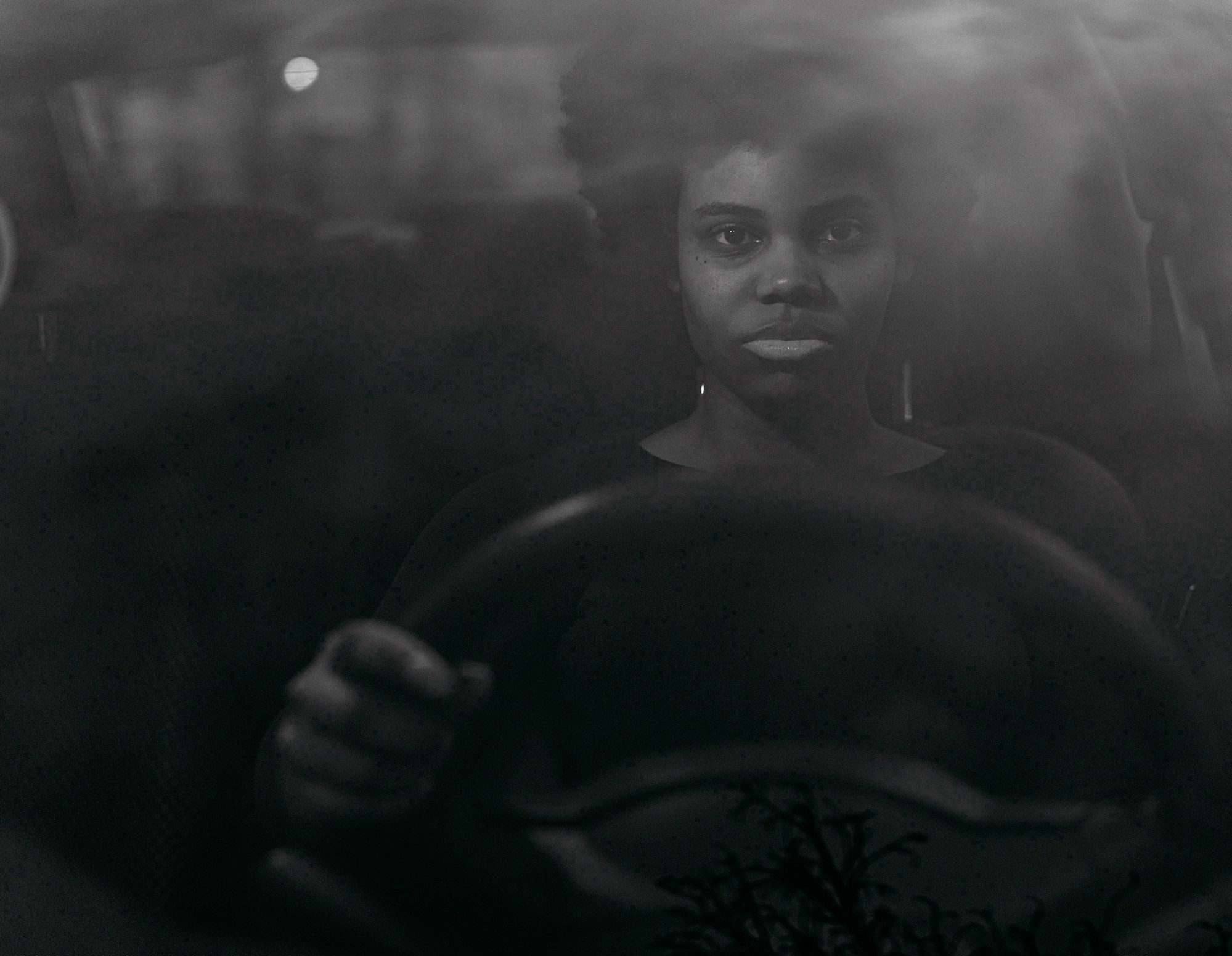 Photograph of someone sitting at the wheel of a car from the Notes on a Native Son: After Baldwin exhibition at Peckham 24 2023