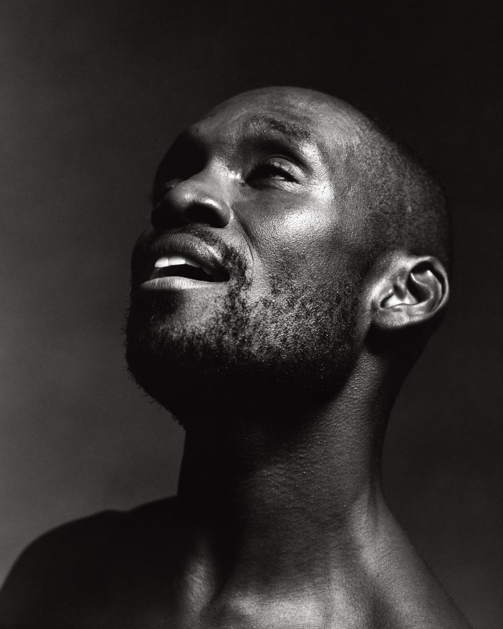 a man with cropped hair in a beard in a close-up shot, his face in a state of euphoria