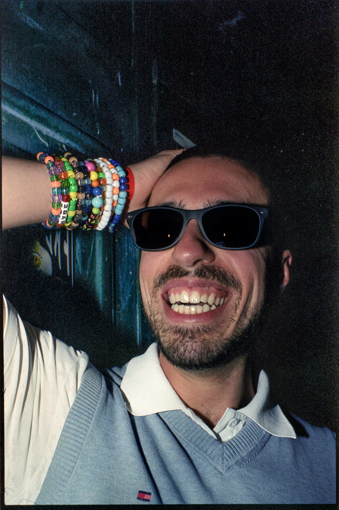 a raver smiling in sunglasses and kandi bracelets in toronto