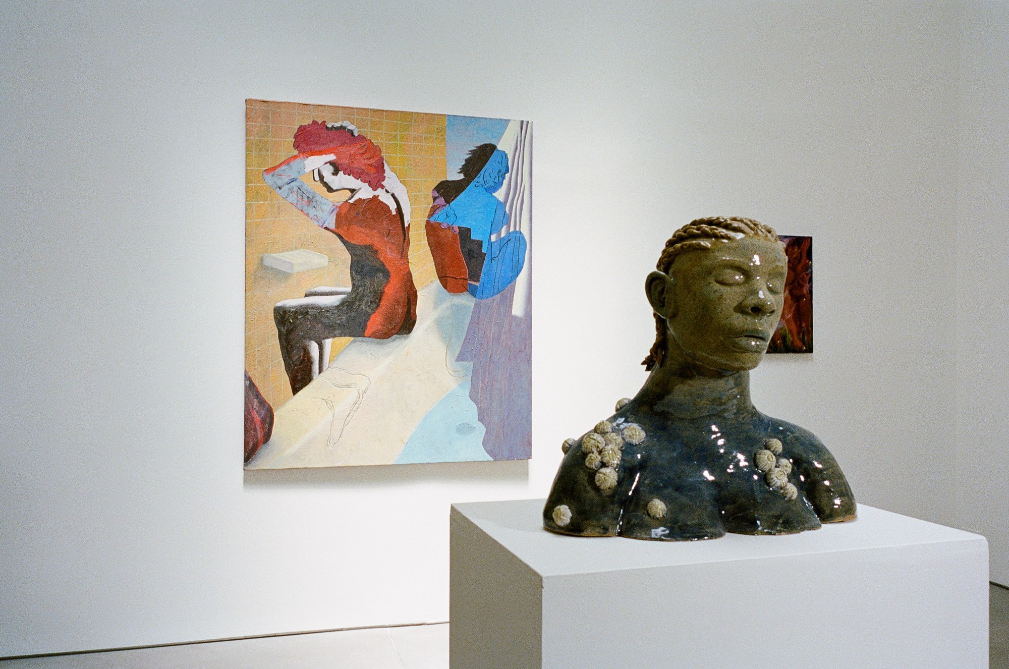 a red, blue, and white painting placed behind a bust at swivel gallery