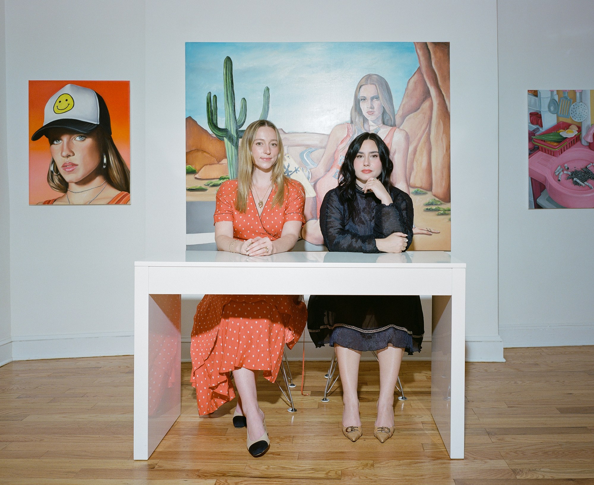 the owners of tcotchke gallery sitting at a white table at their gallery