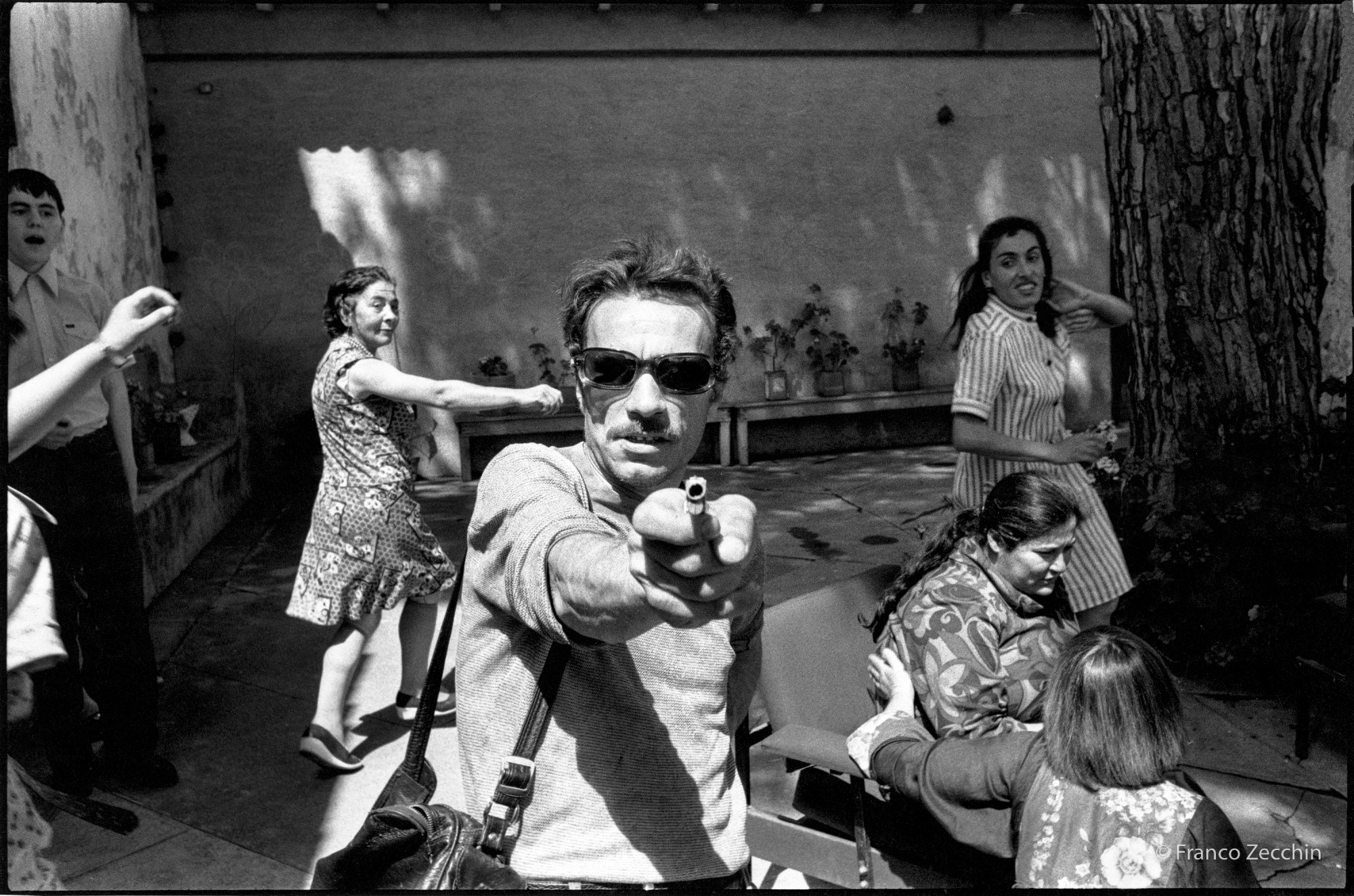 black-and-white still from a movie by Franco Zecchin where a man is holding a gun towards the screen.