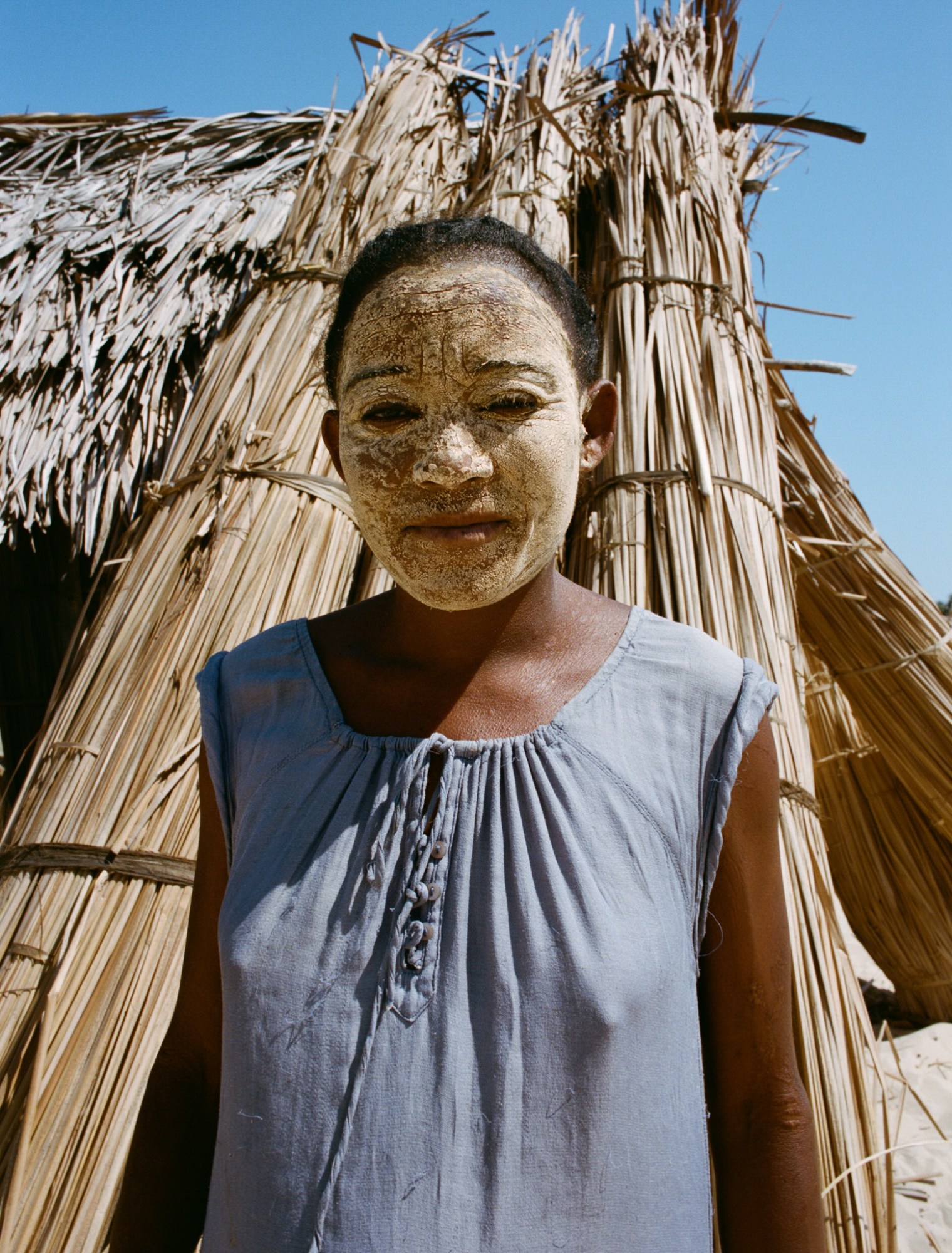 a woman wearing a yellow clay mask