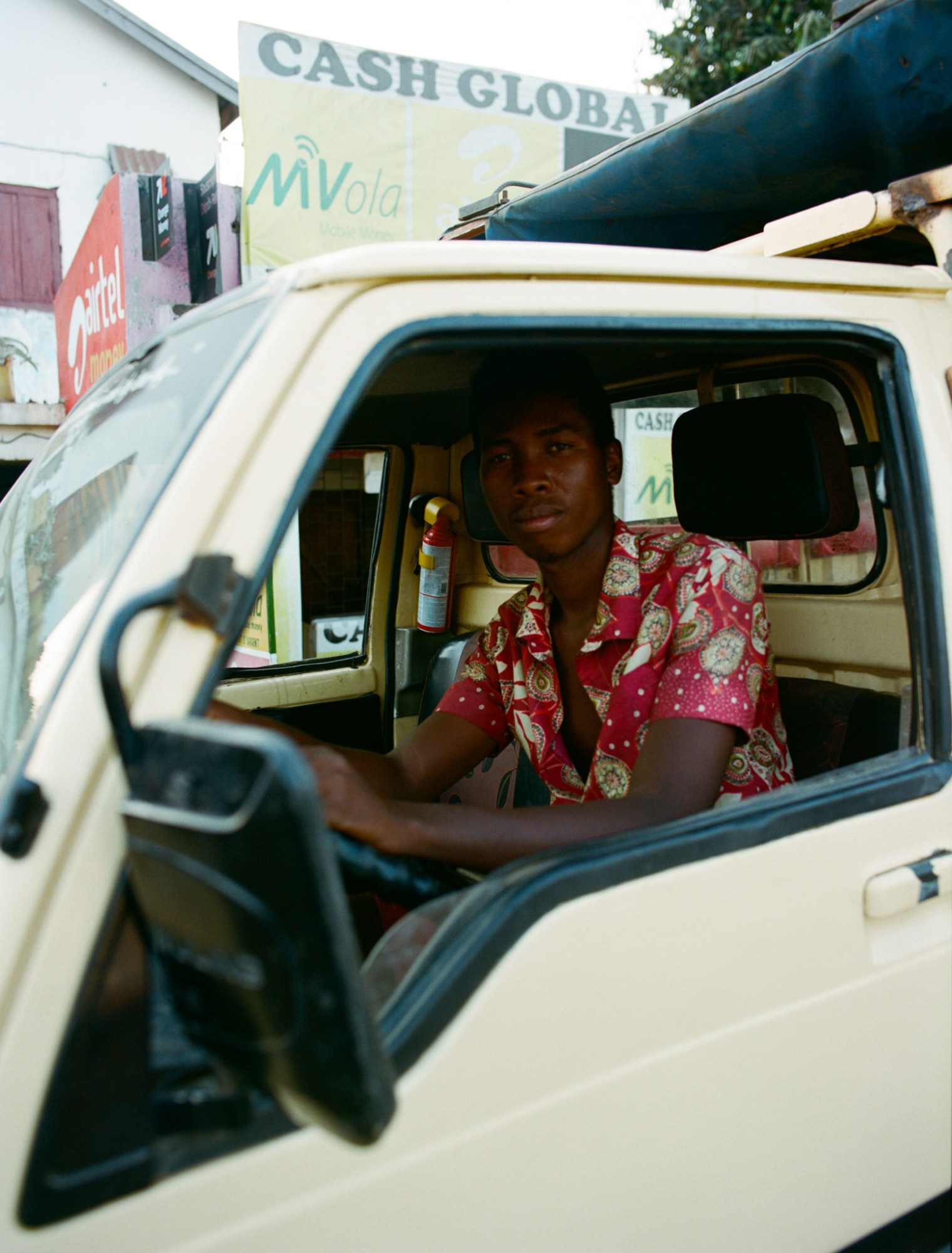 a man in a white truck with a red printed shirt