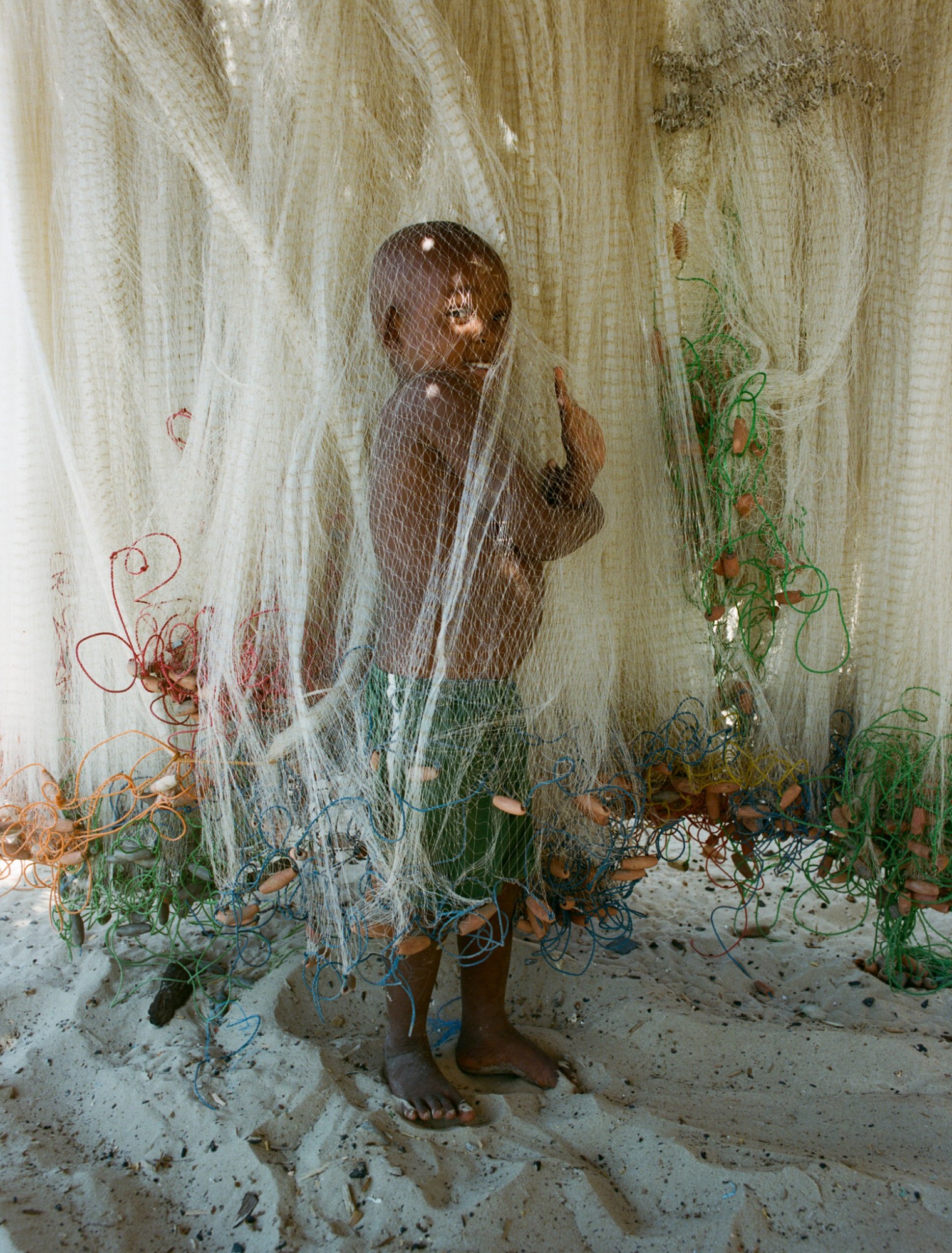 a small child playing in plastic netting