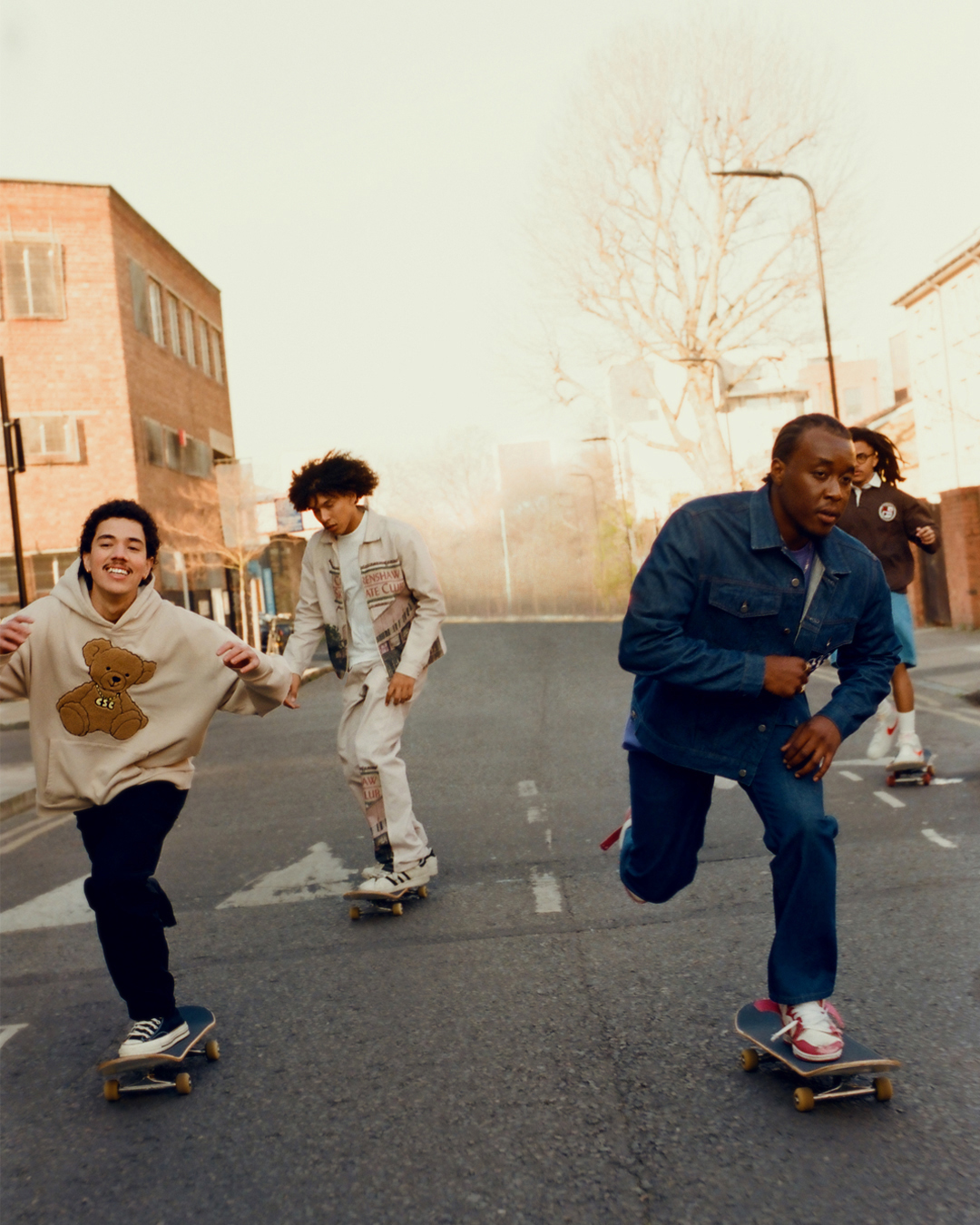 four young mixed race models skate through the streets of london