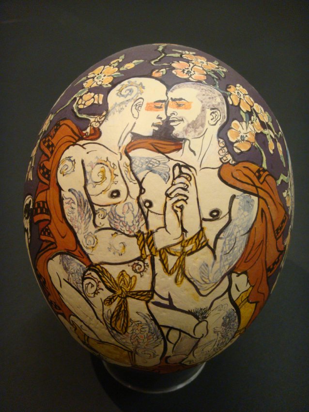 an egg shaped sculpture featuring a naked couple