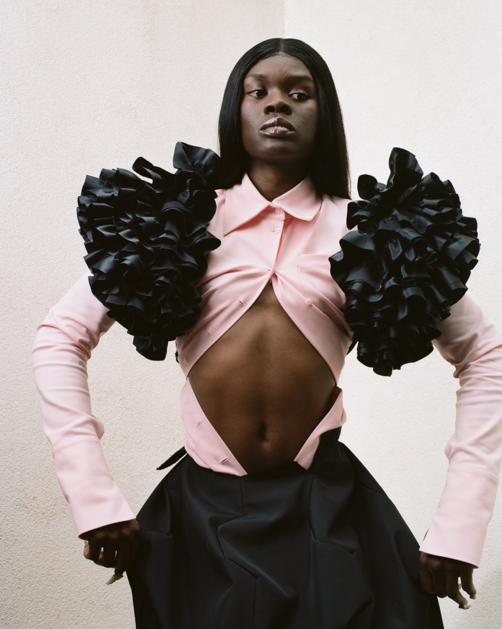 CSM graduate project of Alisa Dyundik of a girl in a pink top and frilly sleeves and black skirt