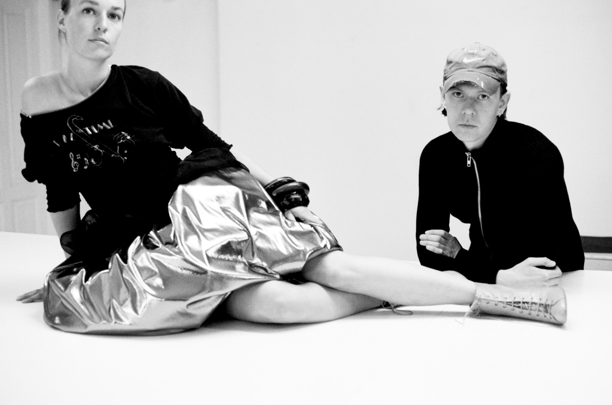 nicklas skovgaard posing with a model wearing in a metallic skirt and top