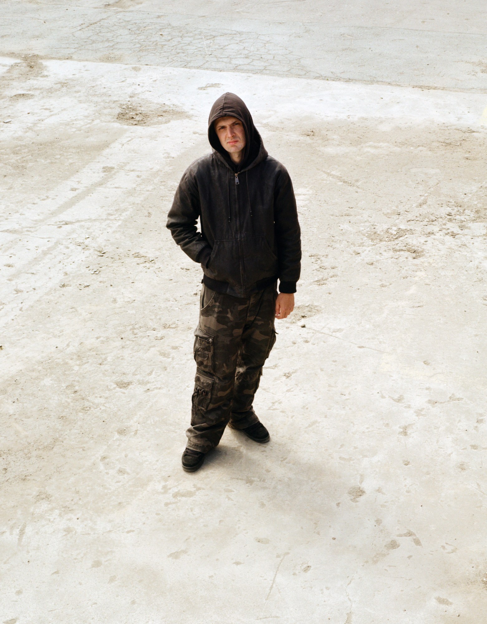 Peter Lundvald Nielsen looking up at the camera in a hoodie and camo pants