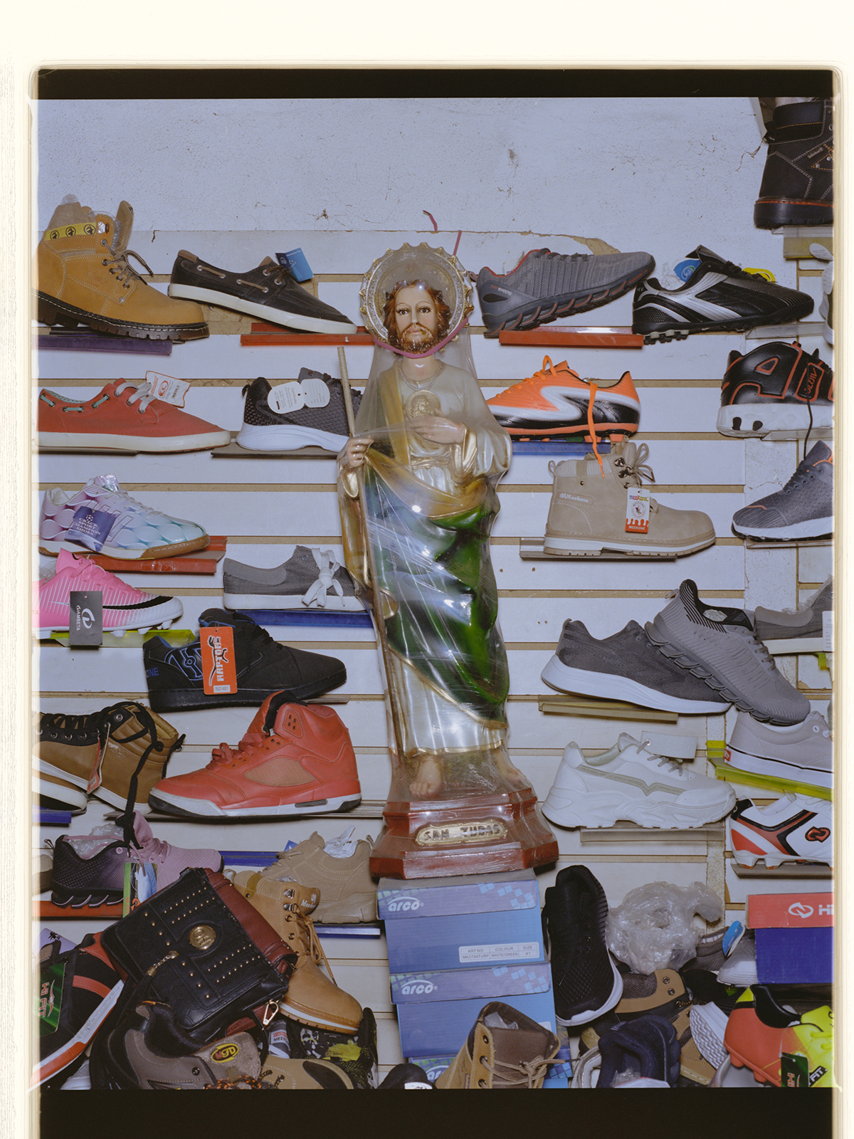 a jesus statue surrounded by sneakers and shoes