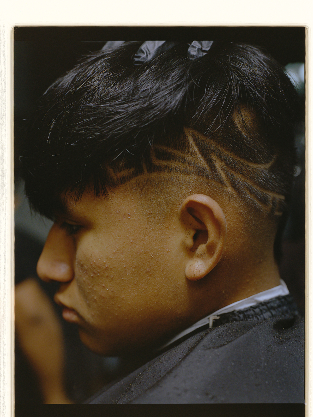 side profile of a boy with a design shaved into his head