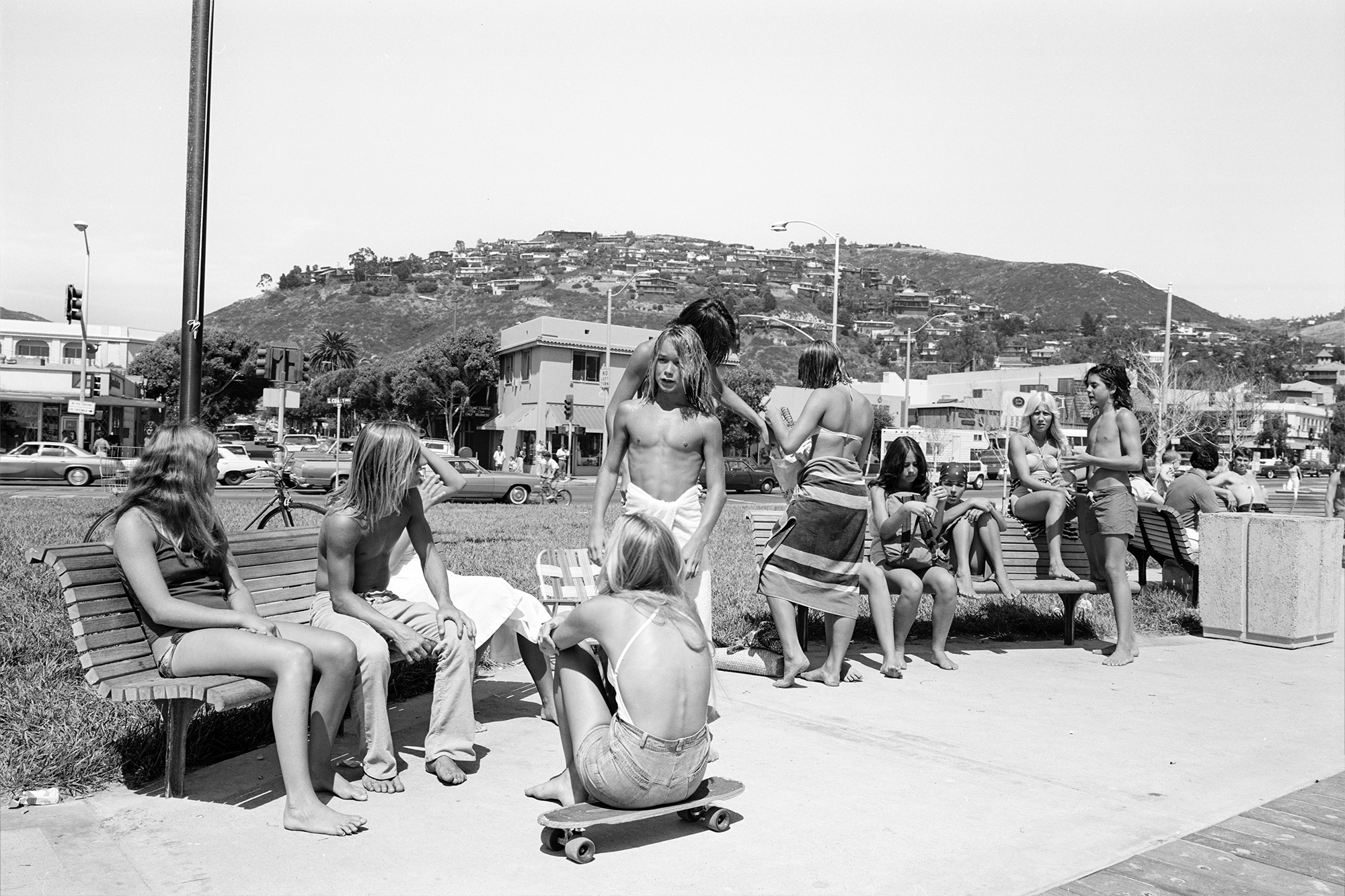 black-and-white image of teenagers handing around in swimwear