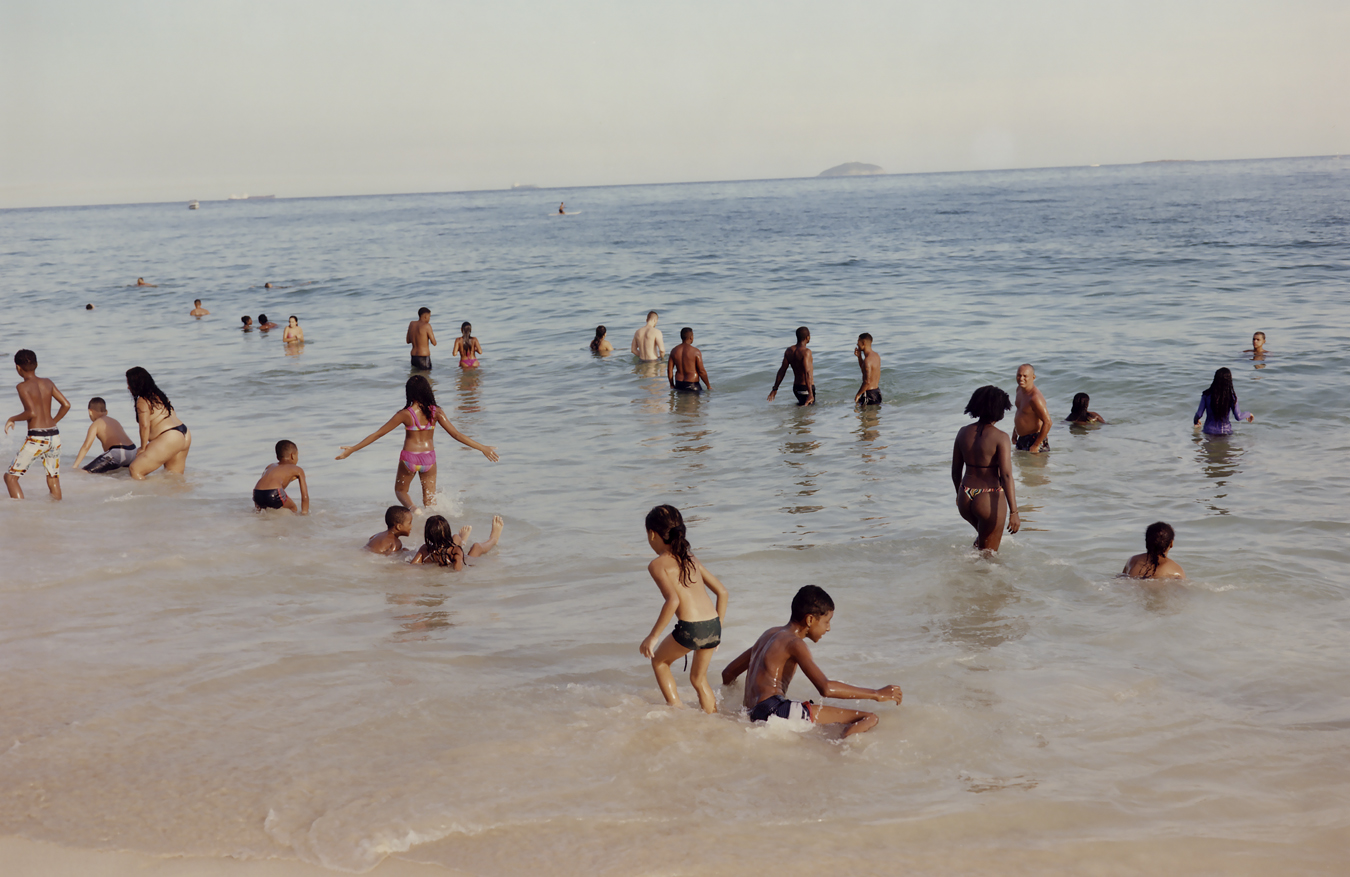 people on the beach in the sea photographed by Vava Ribero