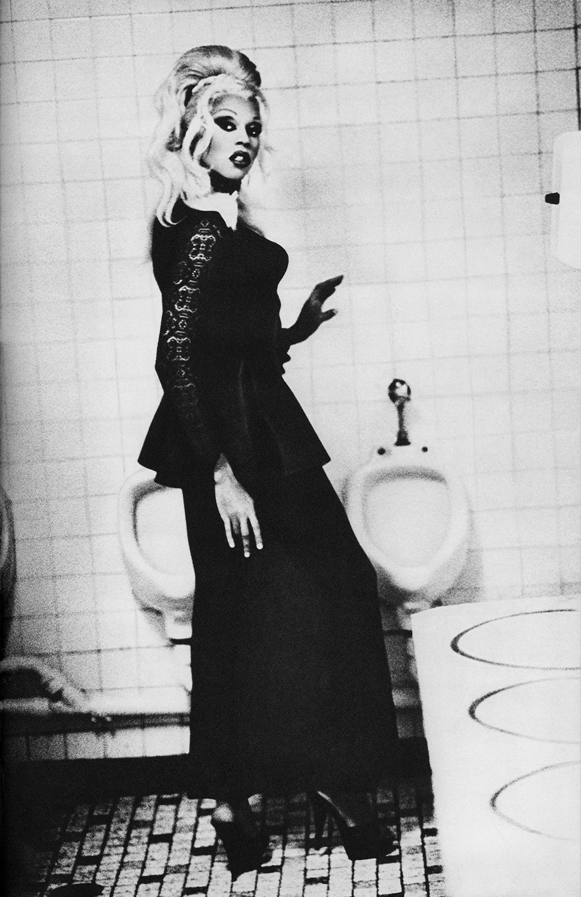 rupaul posing in front of a urinal by ellen von unwerth