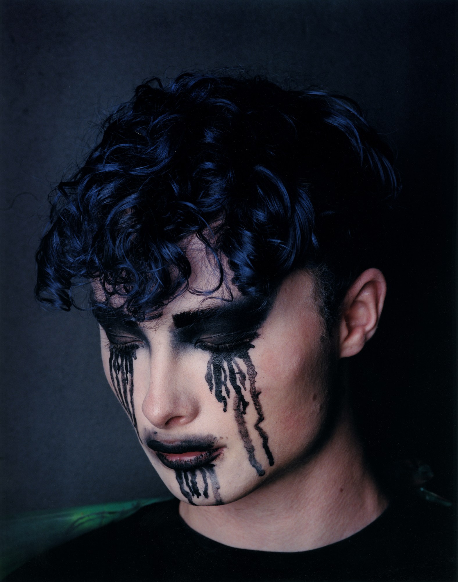 a person with heavy gothic eye make-up that is painted to look like it's running