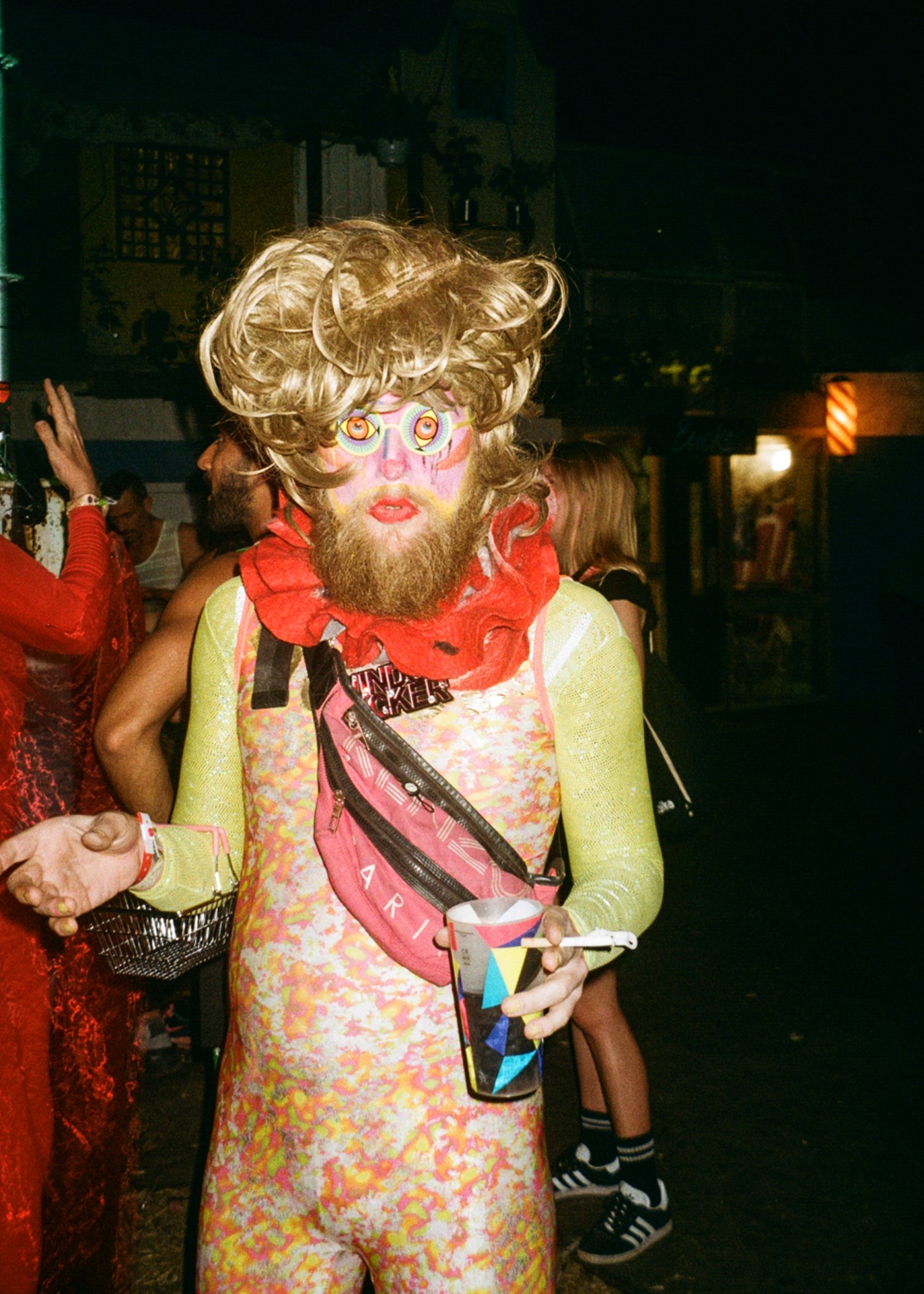 a club goer in a printed catsuit and blone wig