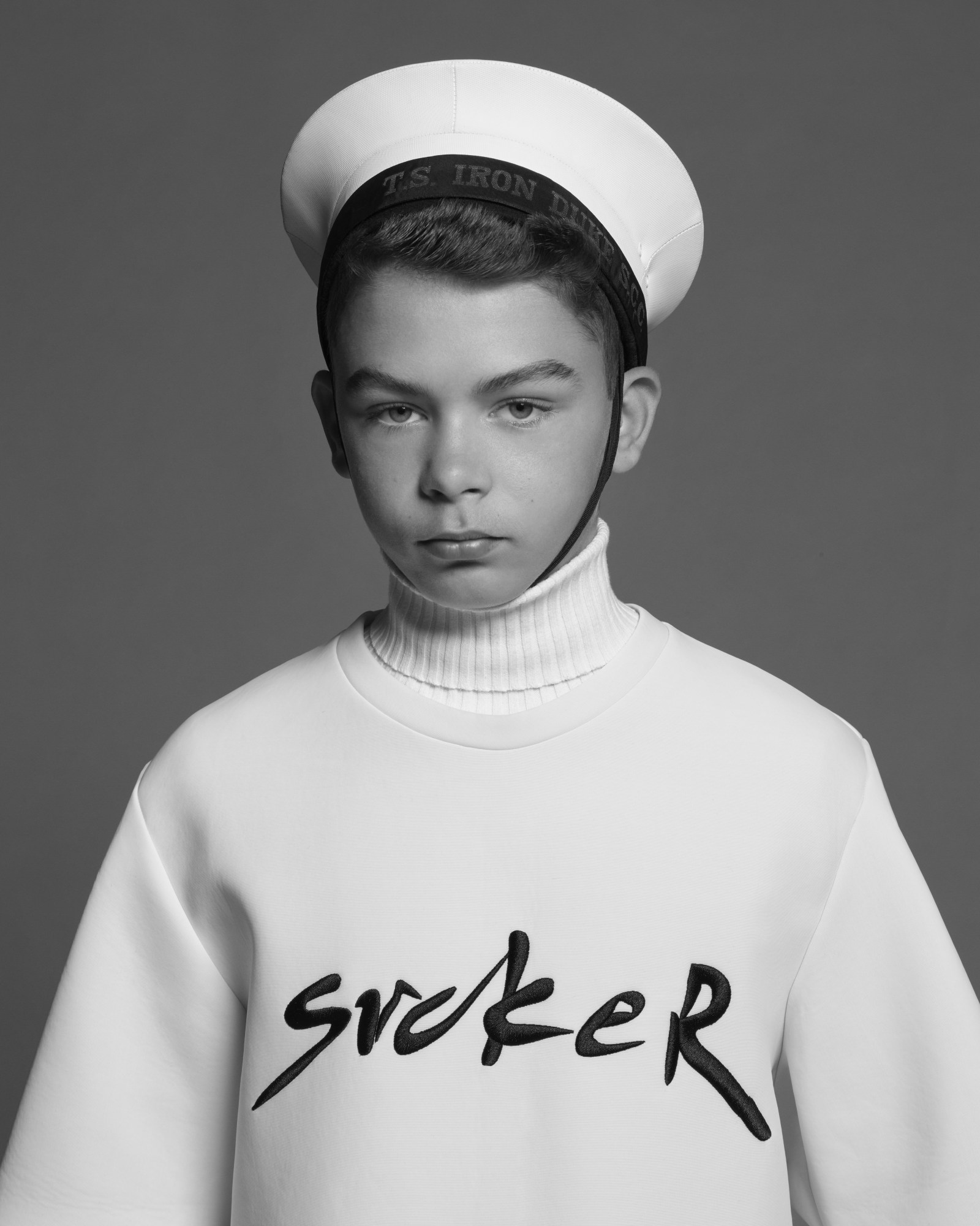 a kid in a sailor hat shot in a studio