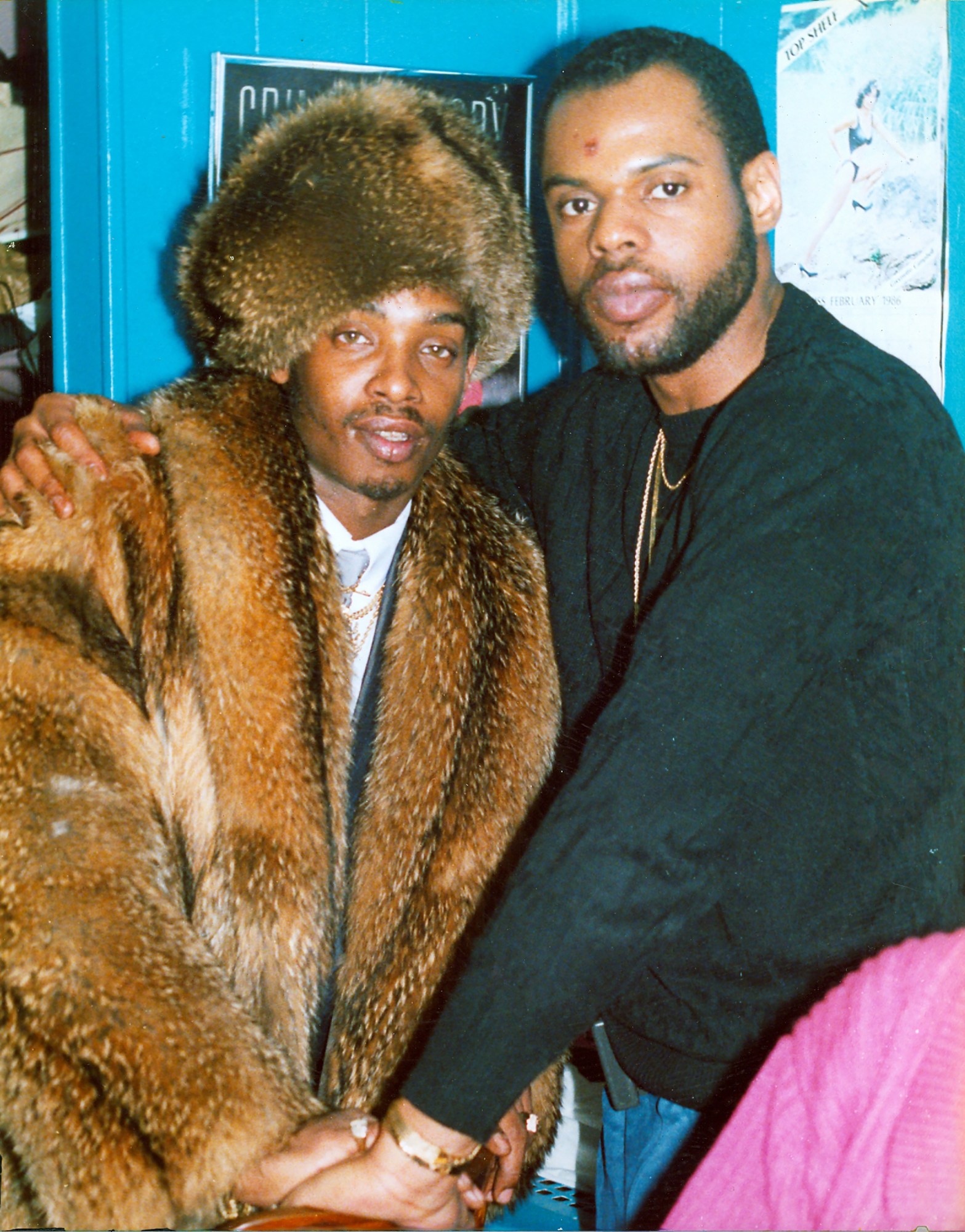 a robert d cave sr. photograph of scorpio mel, dressed in a fur jacket and hat, posing with an unknown man wearing a black sweater. both look into the camera.