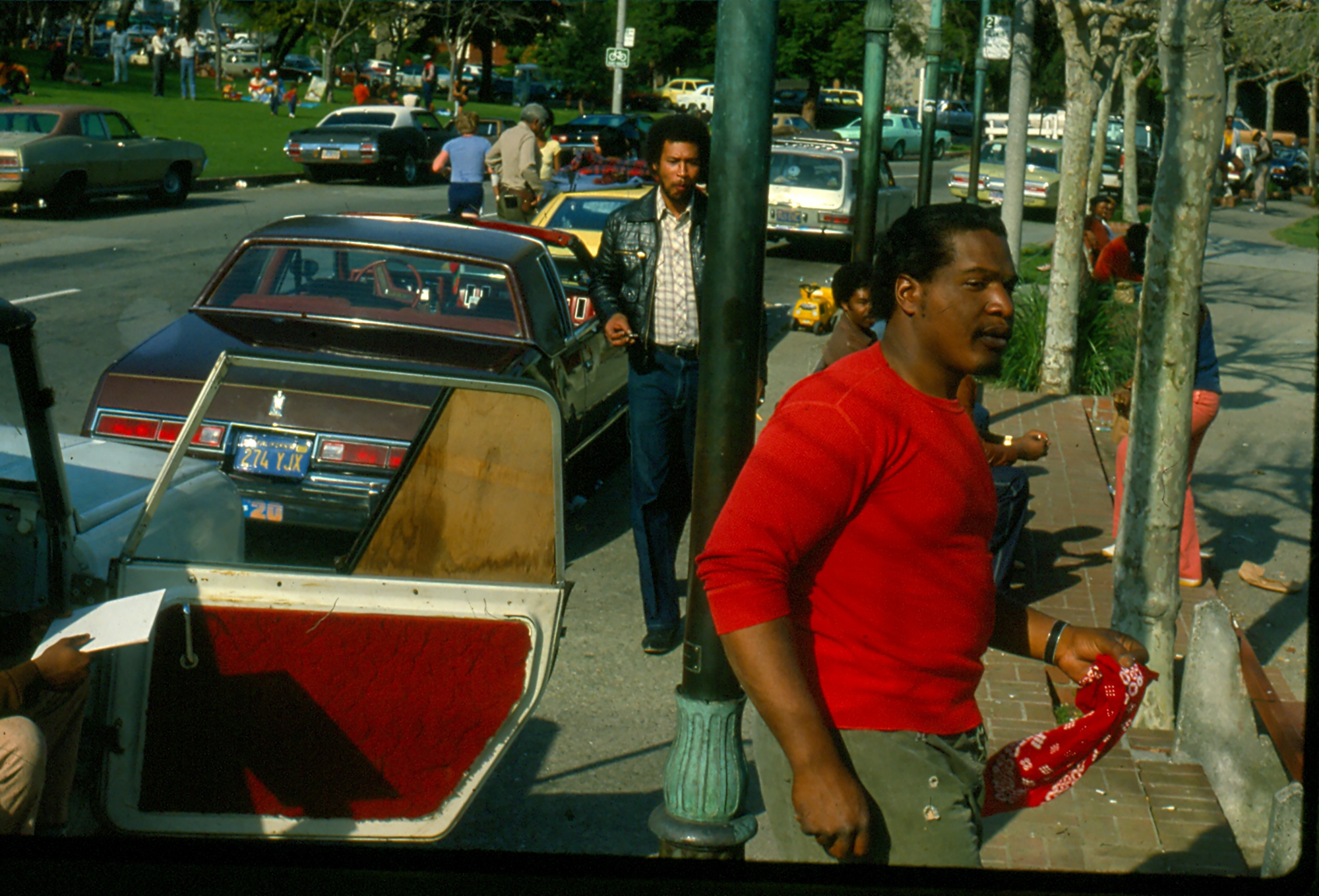 a robert d cave sr. photograph of marvin cave wearing a red sweater walking out of a car onto a street