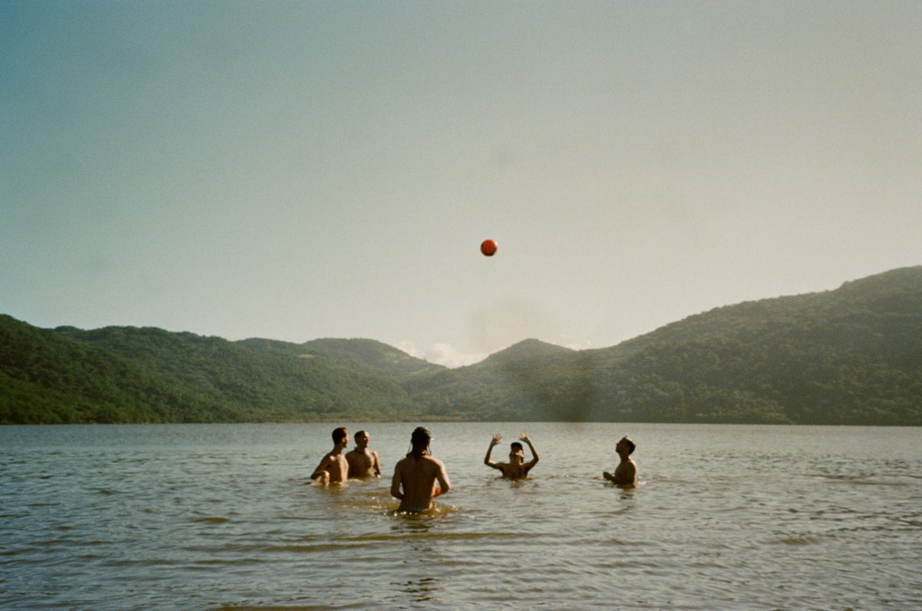 five people playing volleyball in the water in brazil