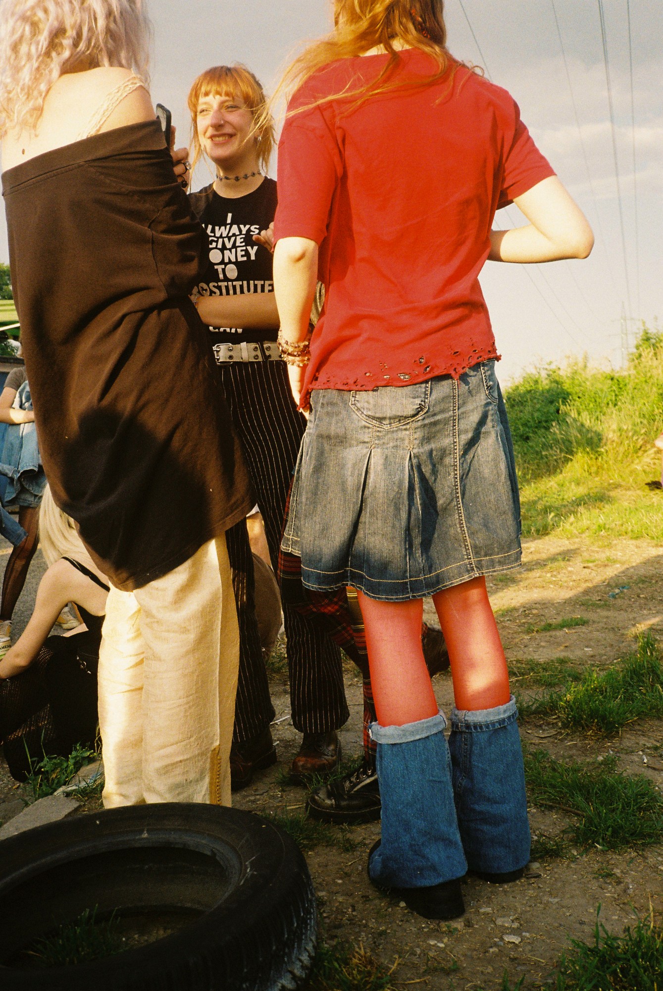 three teenagers standing in a field in the sunshine