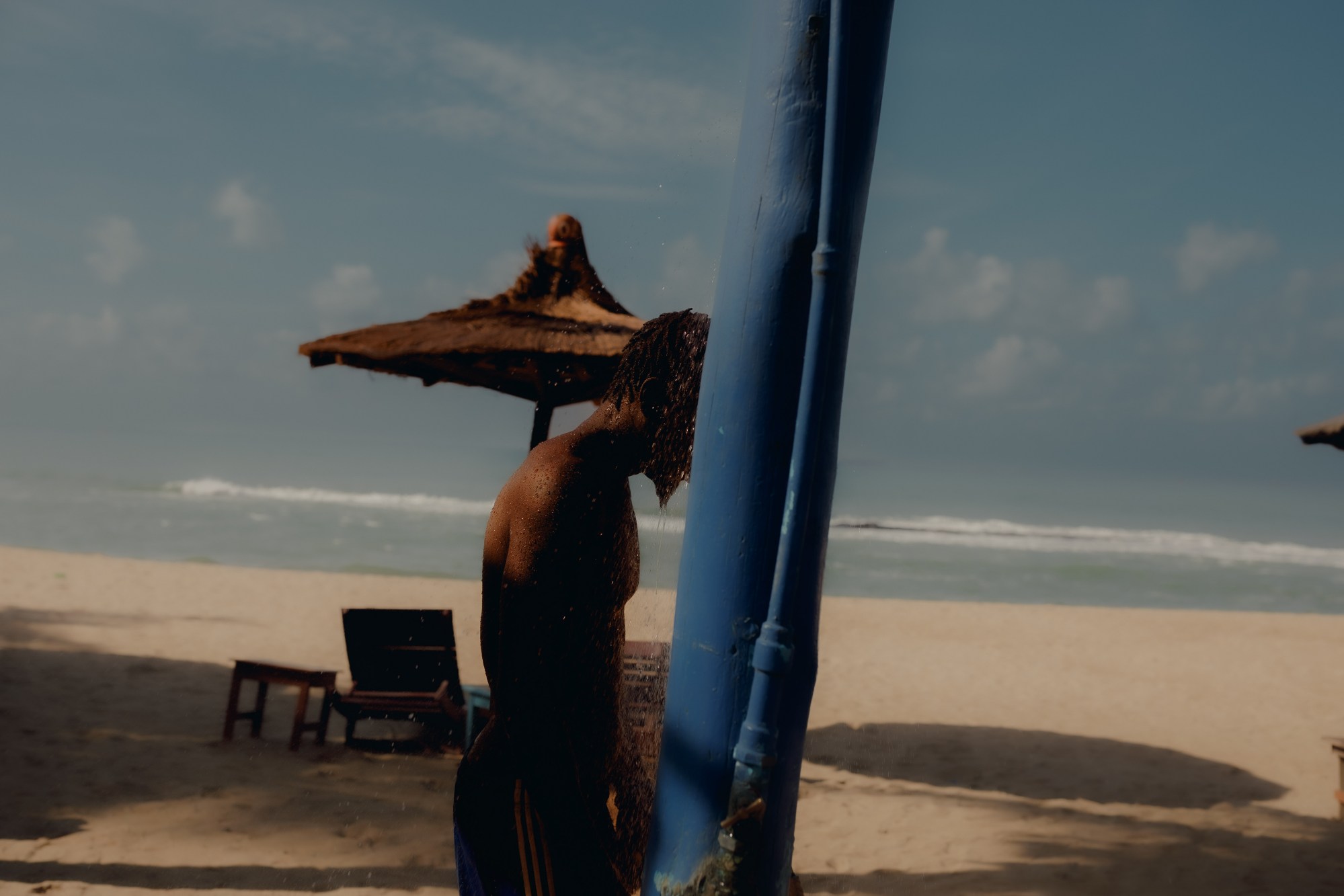 a man showers on the beach in togo