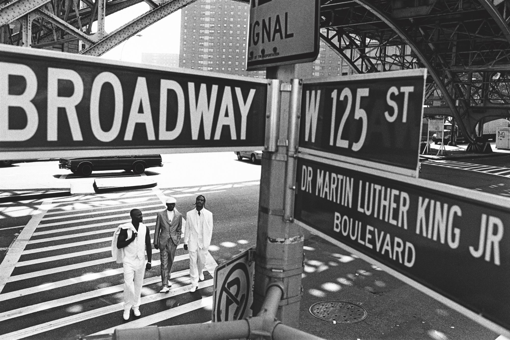 black-and-white image of three men at a crosswalk in new york city