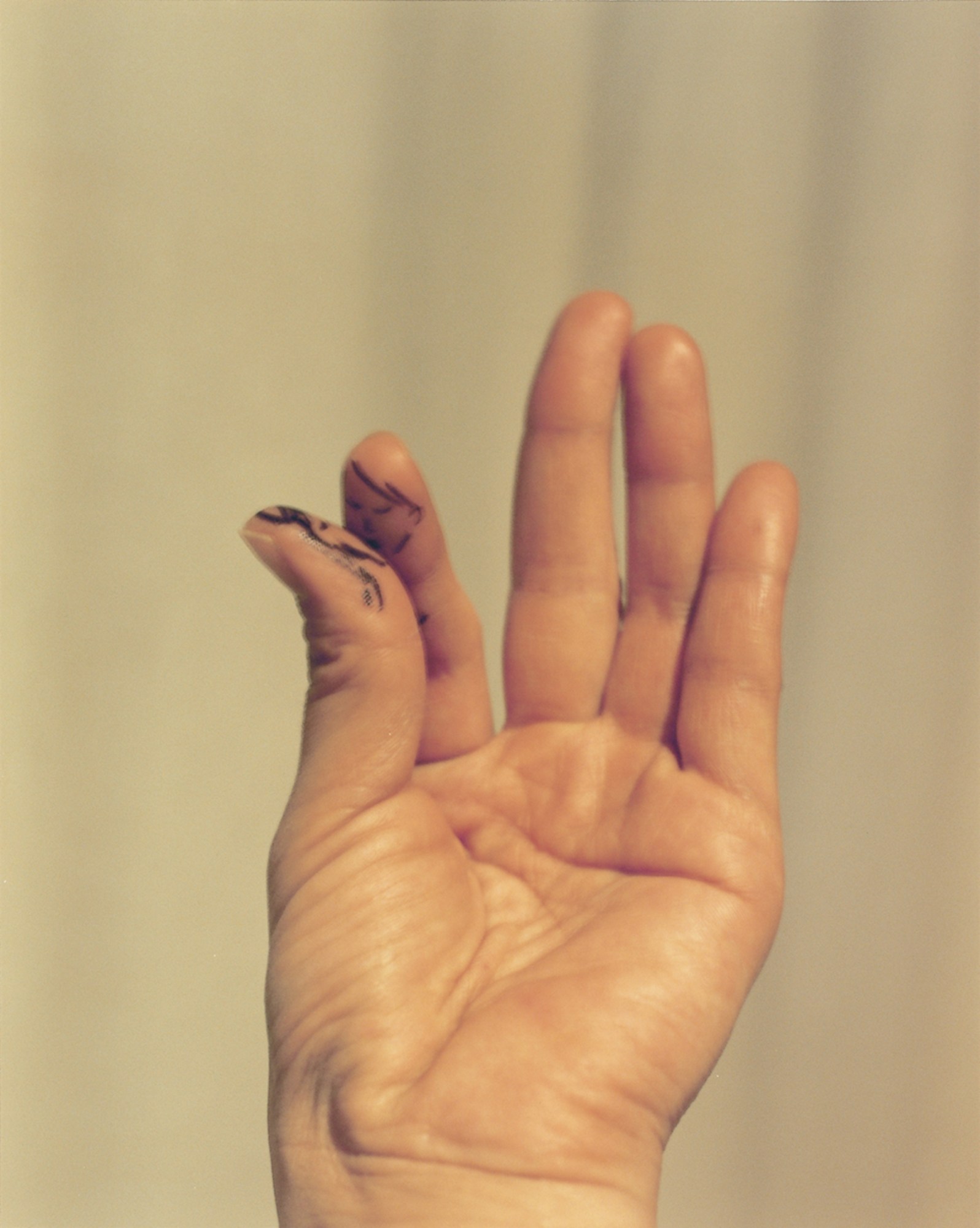 close up of a hand with thumb and one finger smeared with black ink