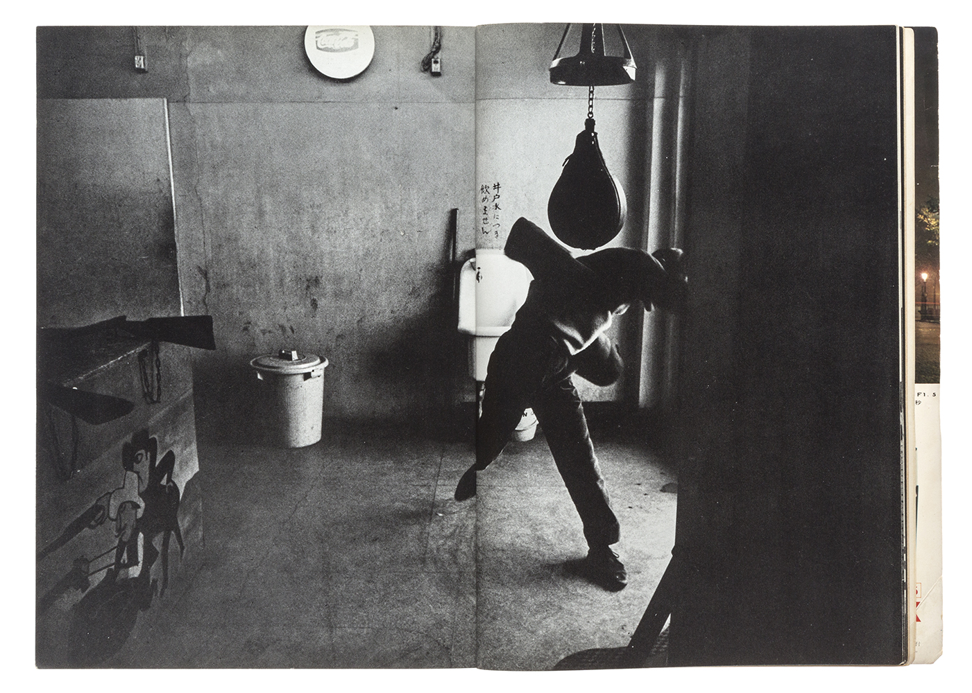 black-and-white image of a boy punching a punching bag in his room