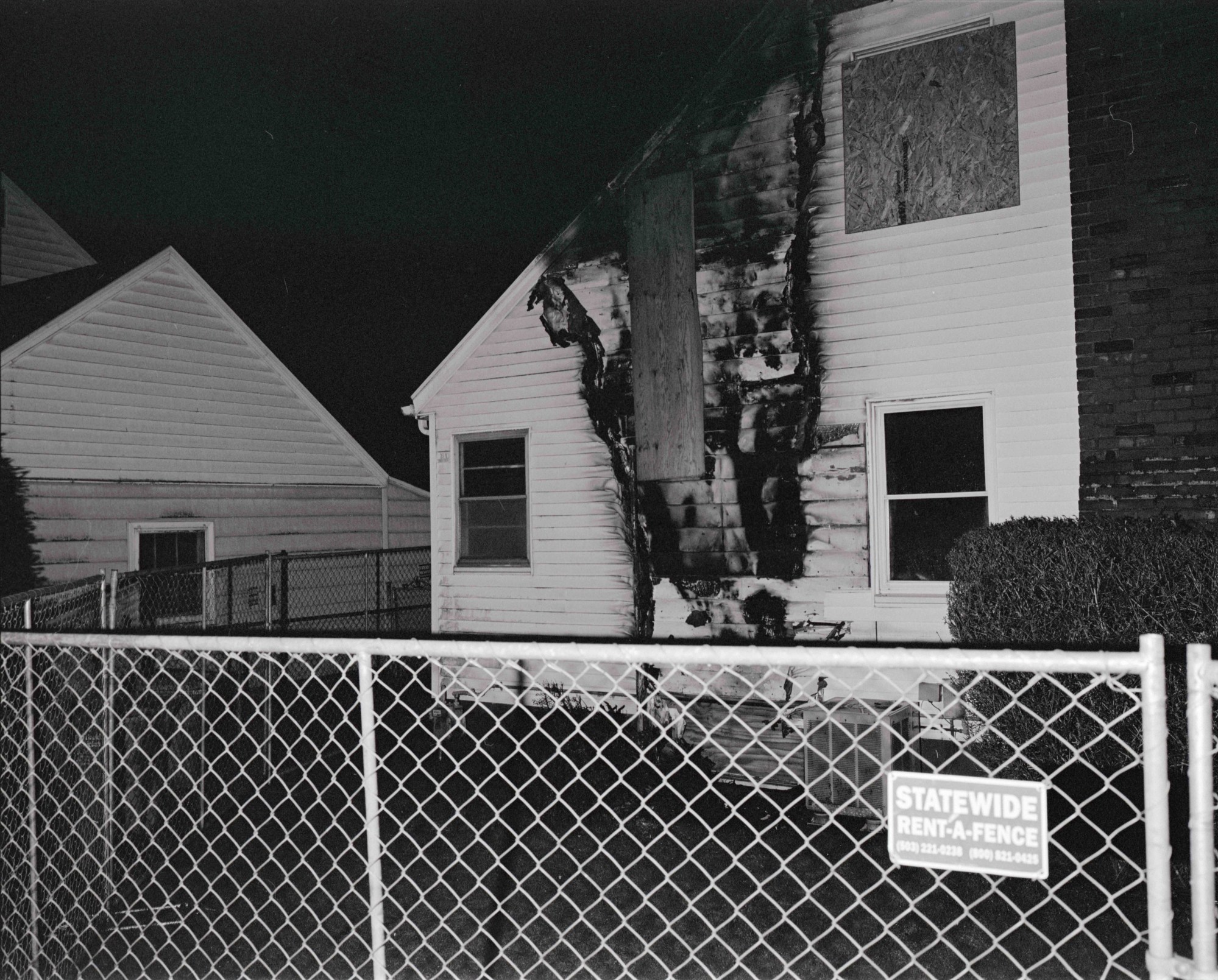 a wire fence in front of a fire damaged White House