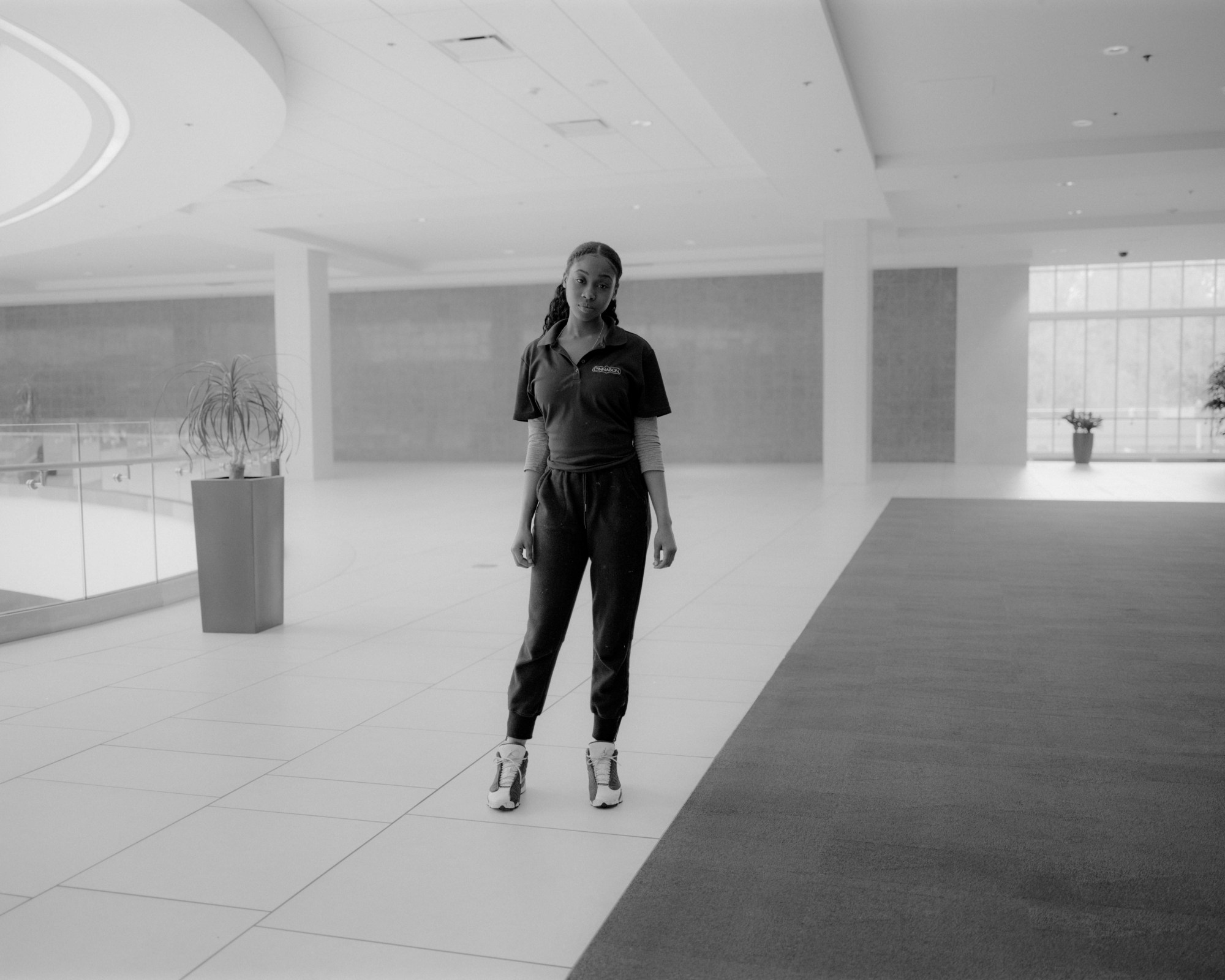 a young girl in an empty tiled room