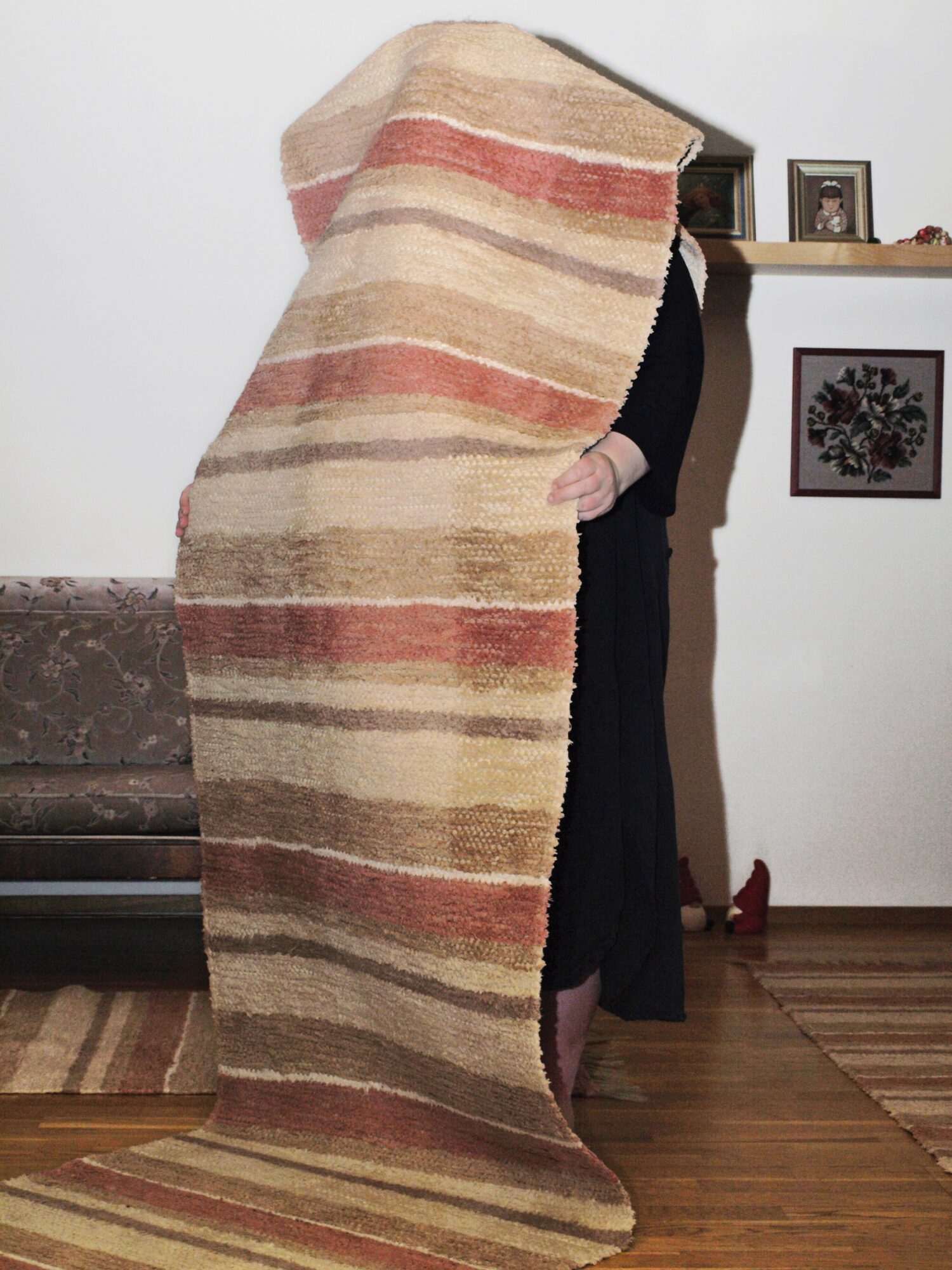 a woman obscured by a striped runner carpet