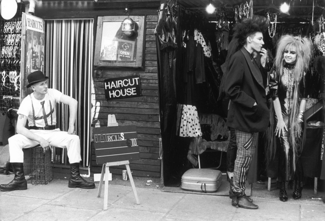 black-and-white photo of three punks hanging out in a shop