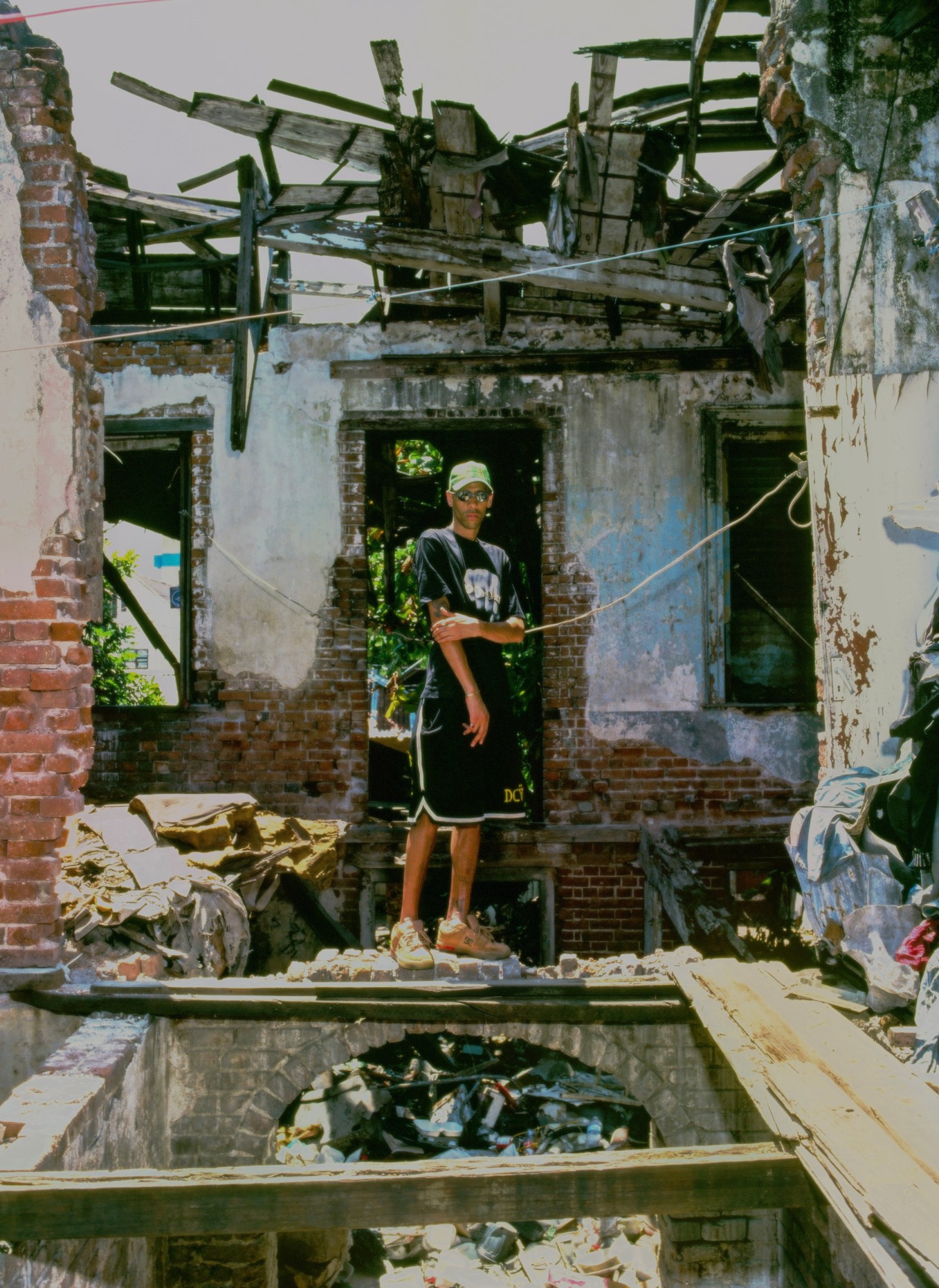 Photograph by Julian Klincewicz of a man wearing DCV'87 standing on the ruins of a crumbling building