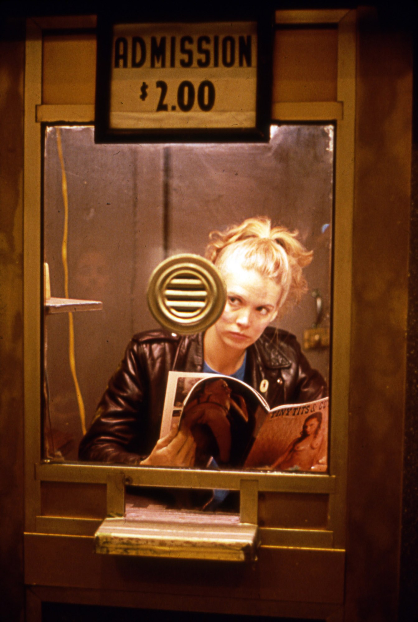 Sandy McLeod as Christine in Variety, sitting in a booth reading a porn mag