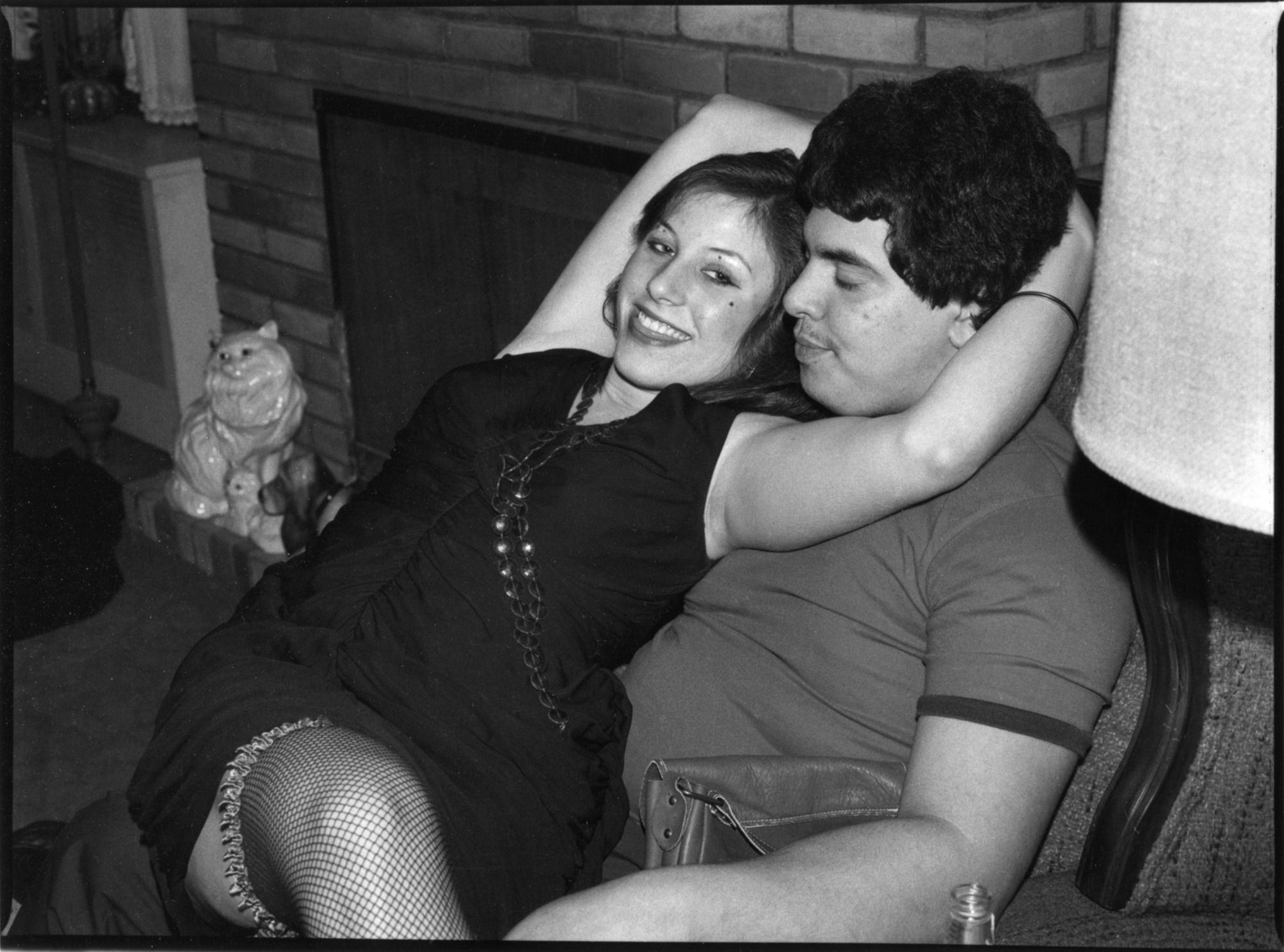 a girl in fishnets sitting on her boyfriends lap in a home in long island