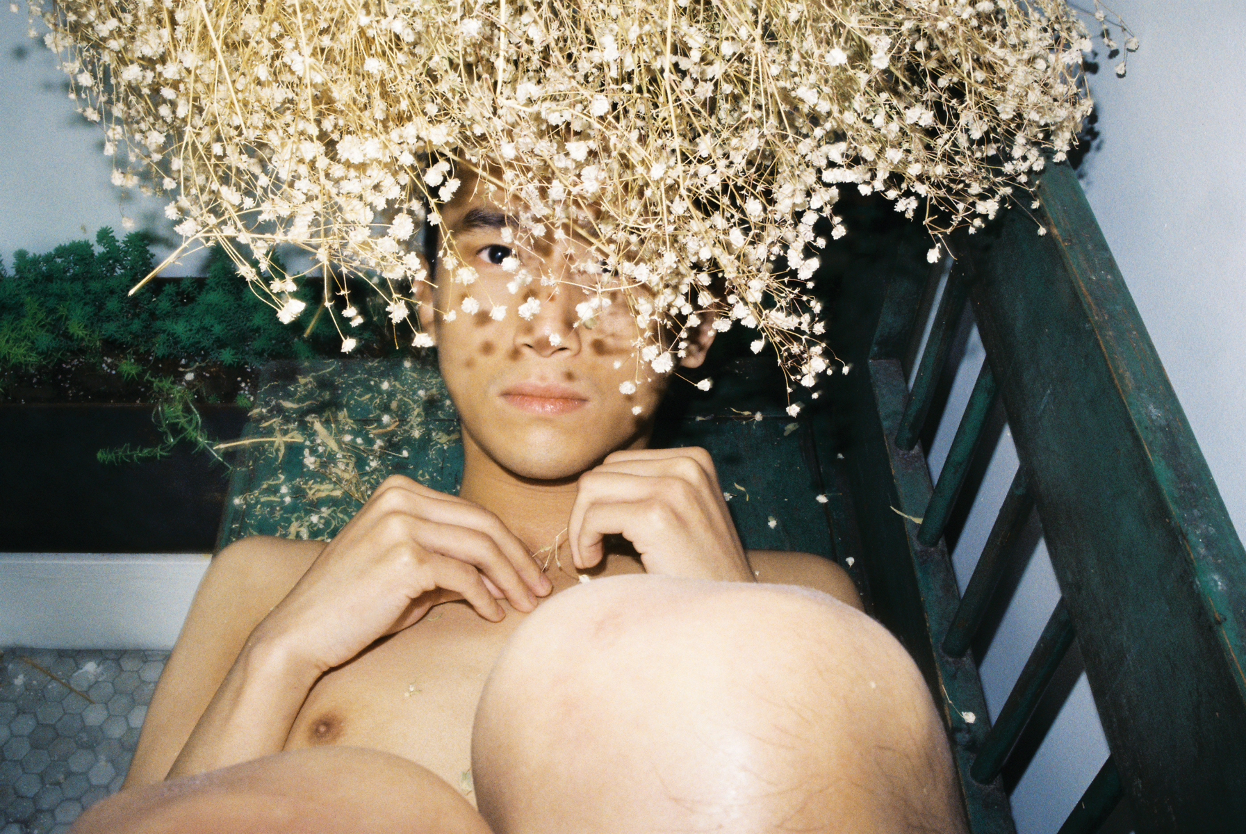 lin zhipeng photograph of a boy hidden behind dried white flowers, made to look like a crown.