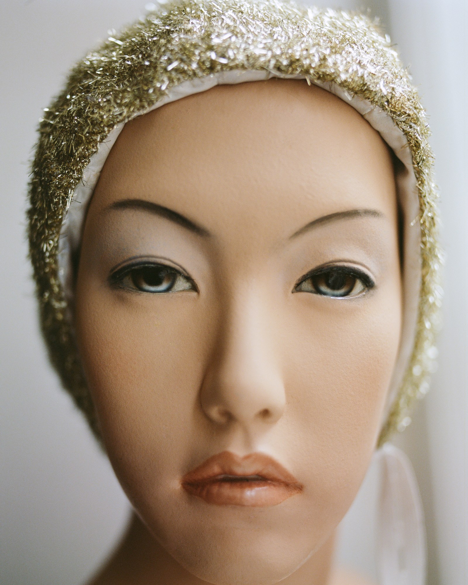 close up of a mannequin in a sequin bonnet by nicklas skovgaard