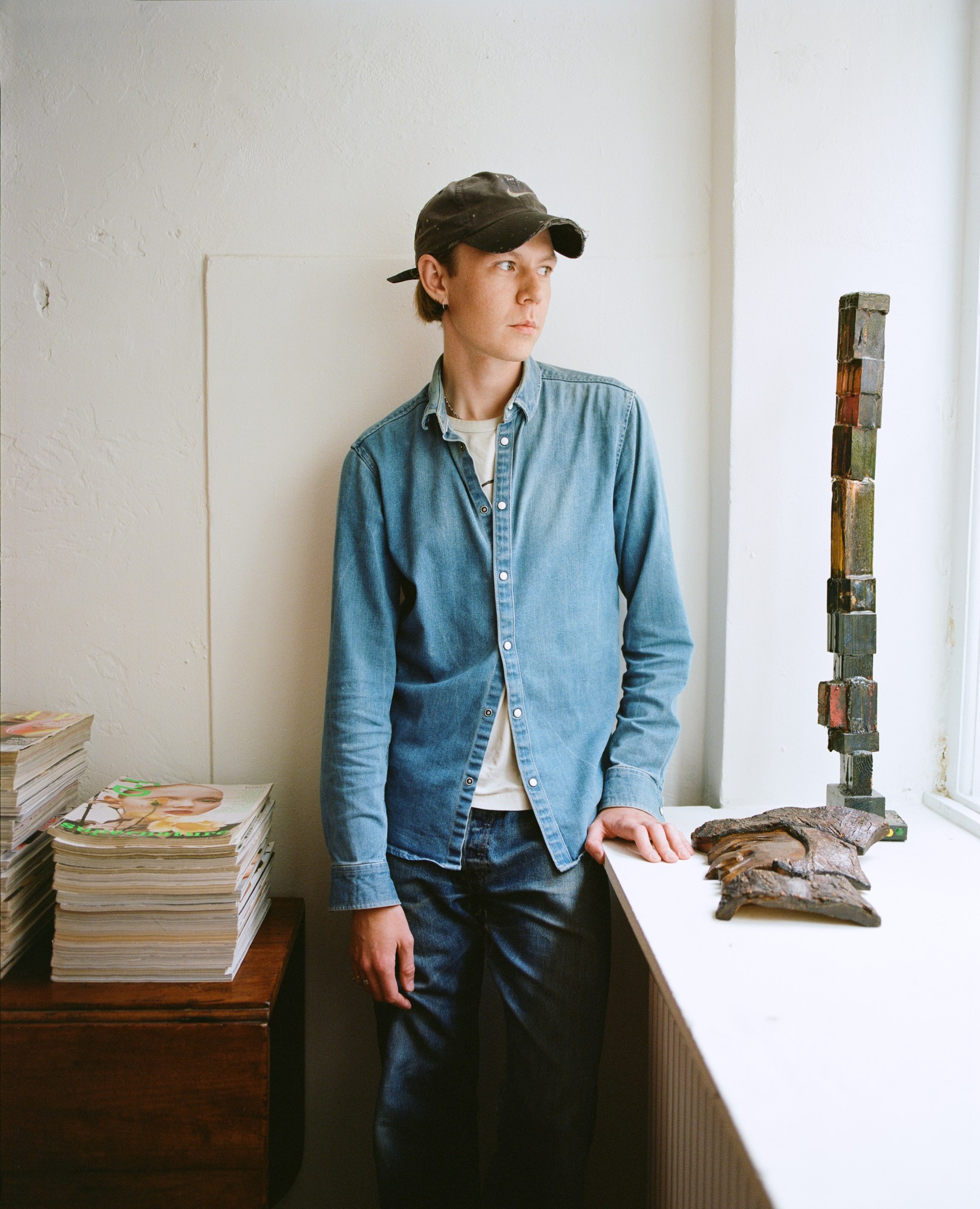 nicklas skovgaard in his studio next to a pile of magazines